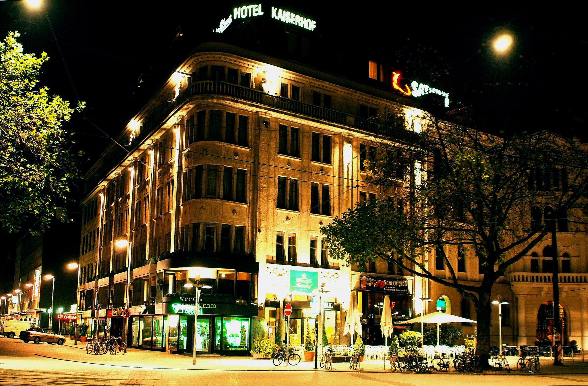 The illuminated building of the Central-Hotel Kaiserhof in Hannover at night.