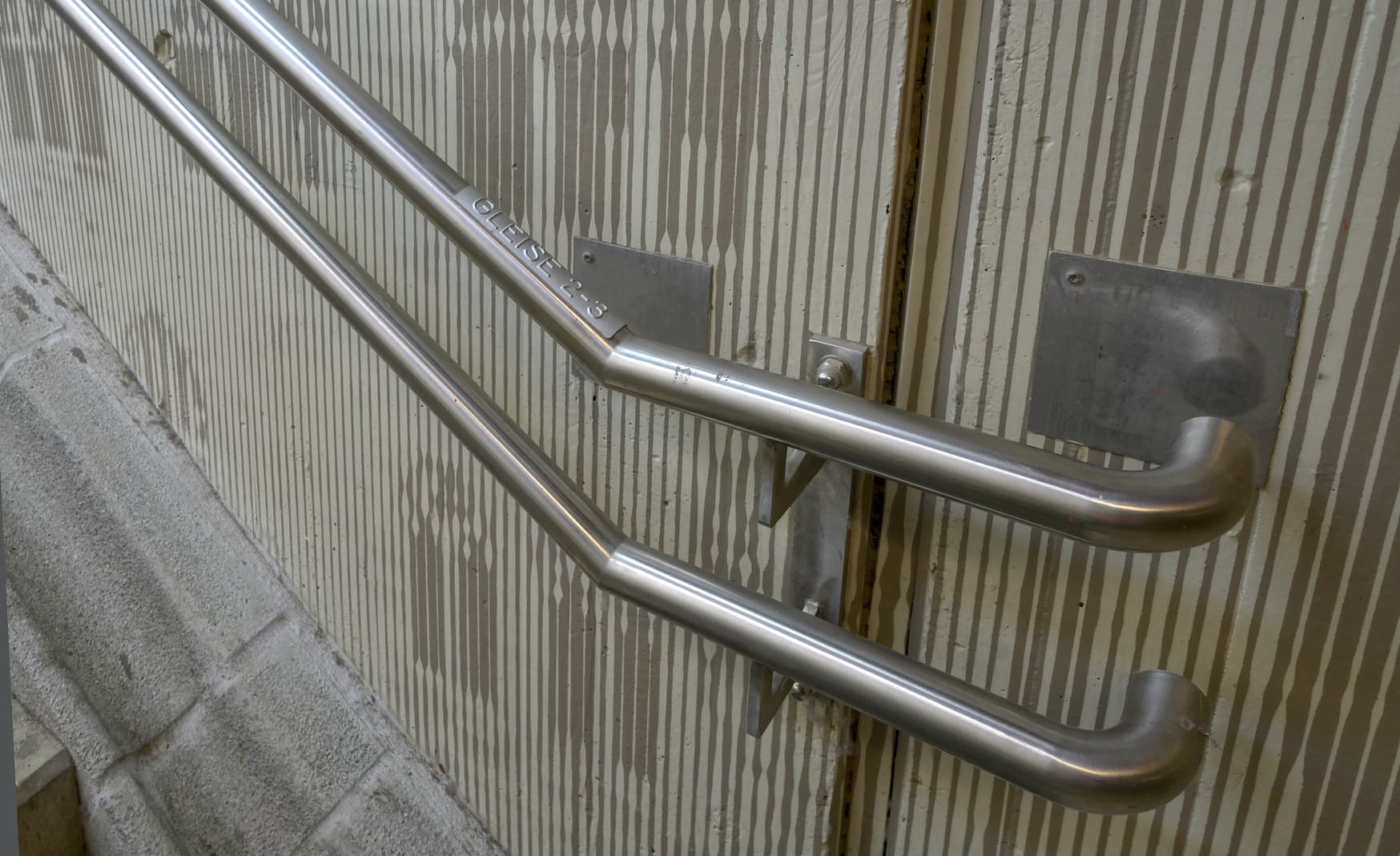 Detailaufnahme eines Treppenhandlaufs mit Braille.