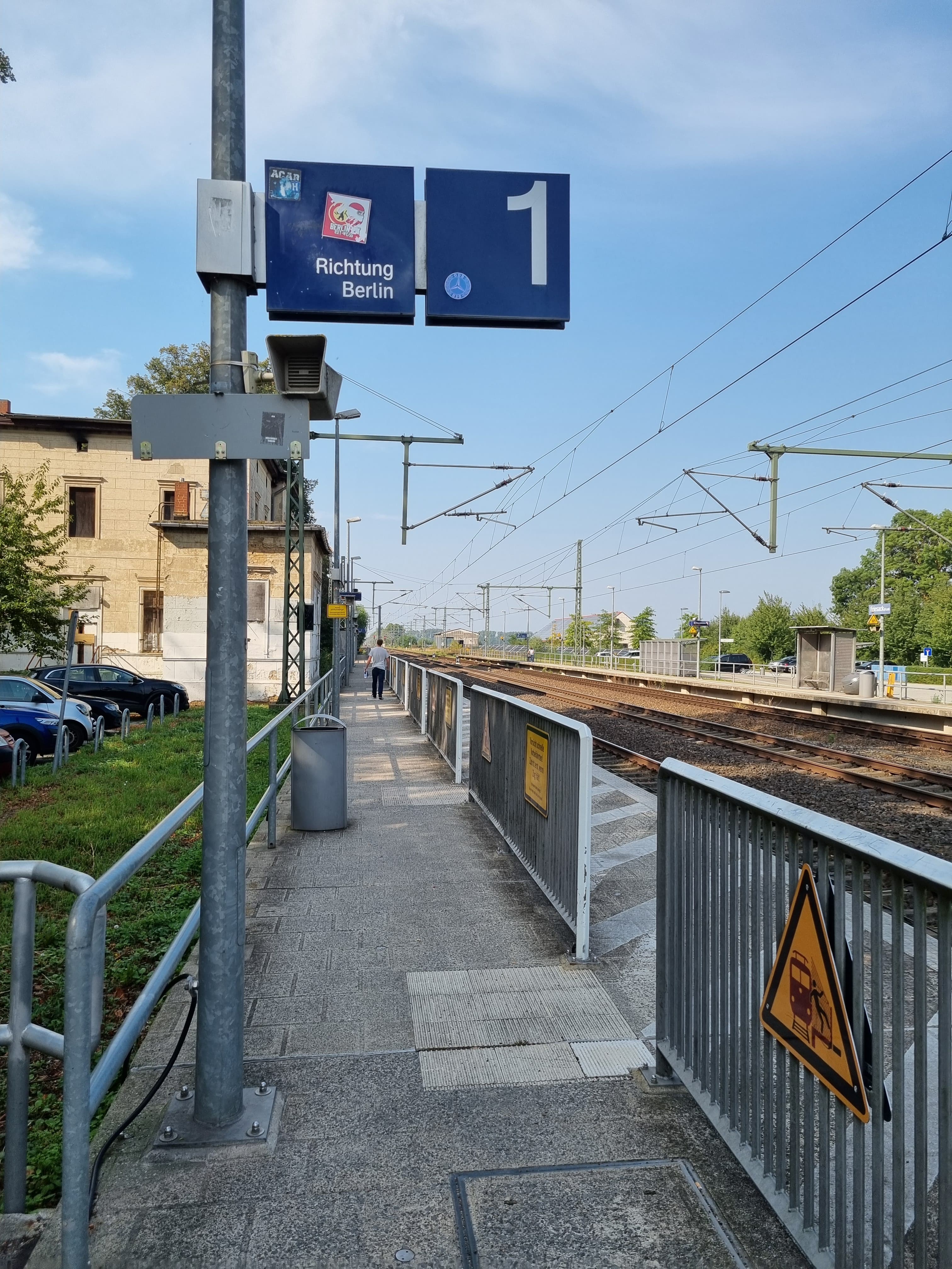 Blick auf den Bahnsteig vor der Neugestaltung, rechts Geländer und Gleise.