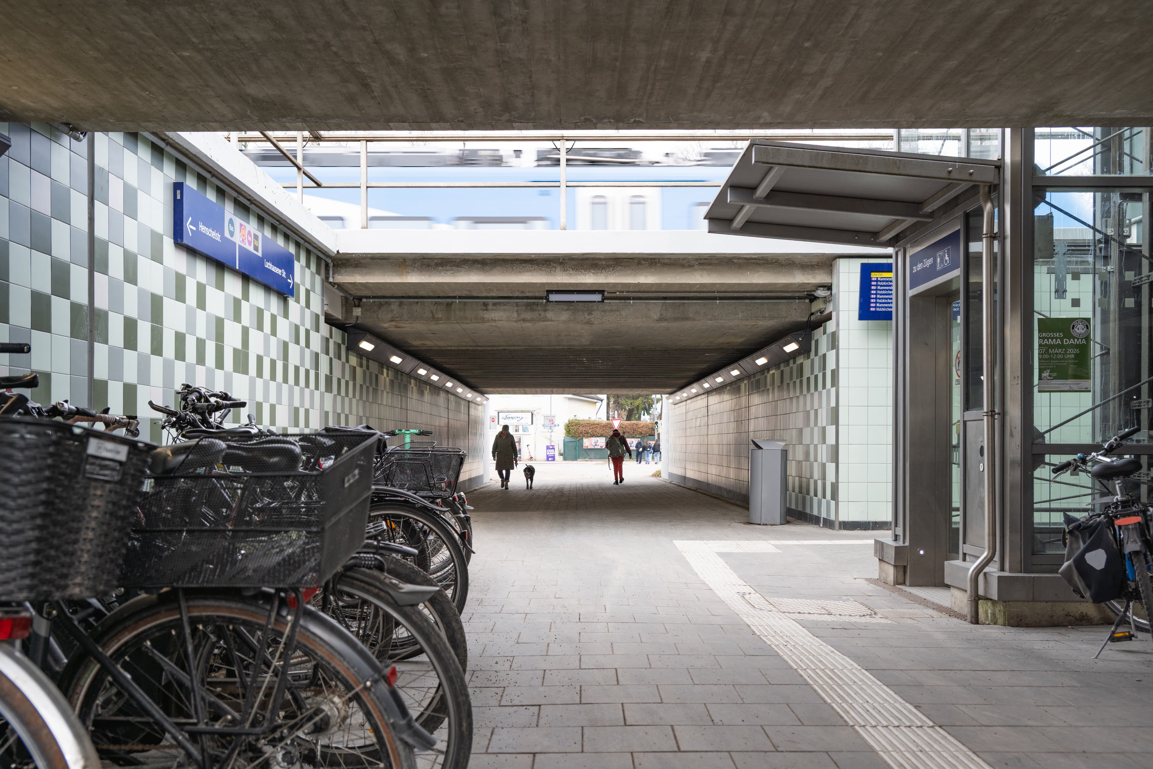 Die aufgewertete Personenunterführung nach der Aufwertung. Links im Vordergrund ordentlich aufgestellte Fahrräder. Mittig laufen Personen durch die freundlichere und helle Unterführung.