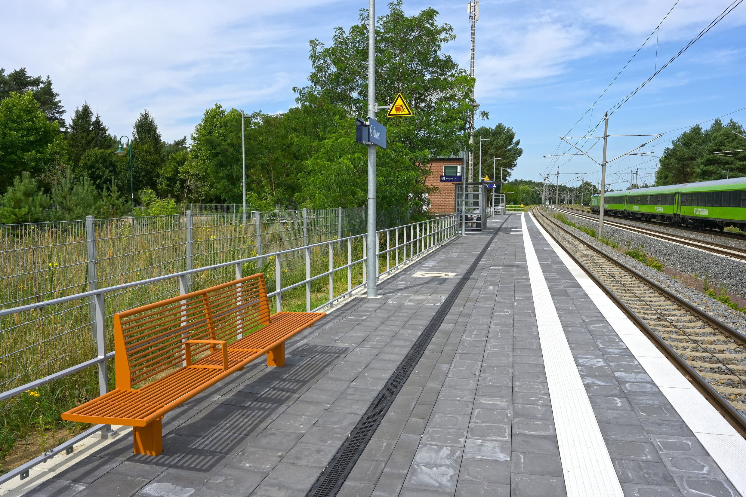 Neue, orangene Sitzbänke am modernisierten Bahnsteig.