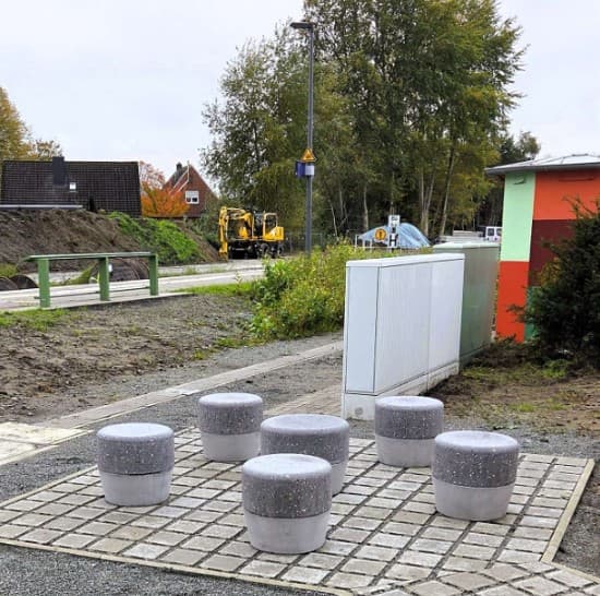 Im Bild 6 runde Beton-Hocker auf einer gepflasterten Fläche