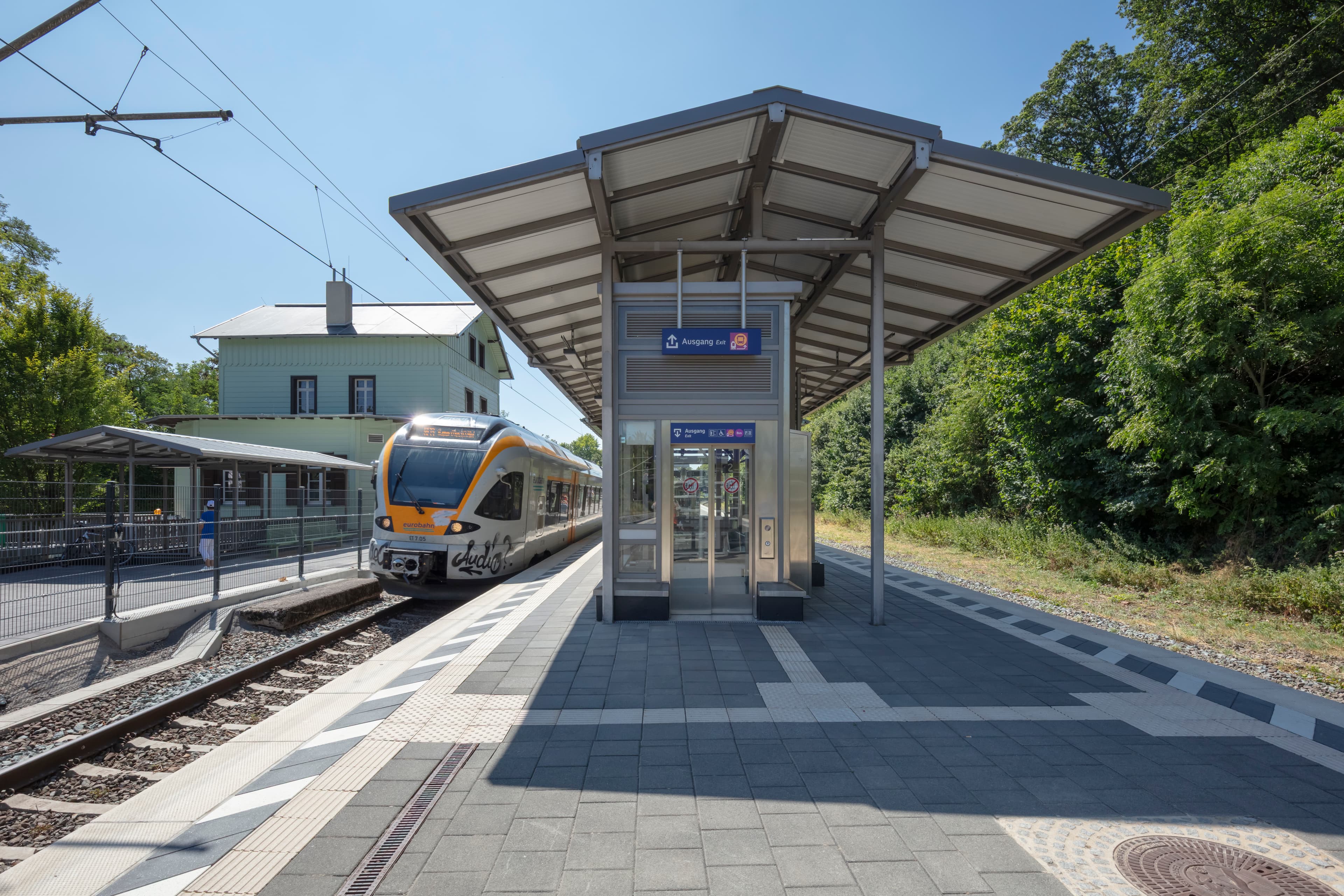 Der Bahnsteig, das historische Bahnsteigdach, der Aufzug und das modernisierte Empfangsgebäude.