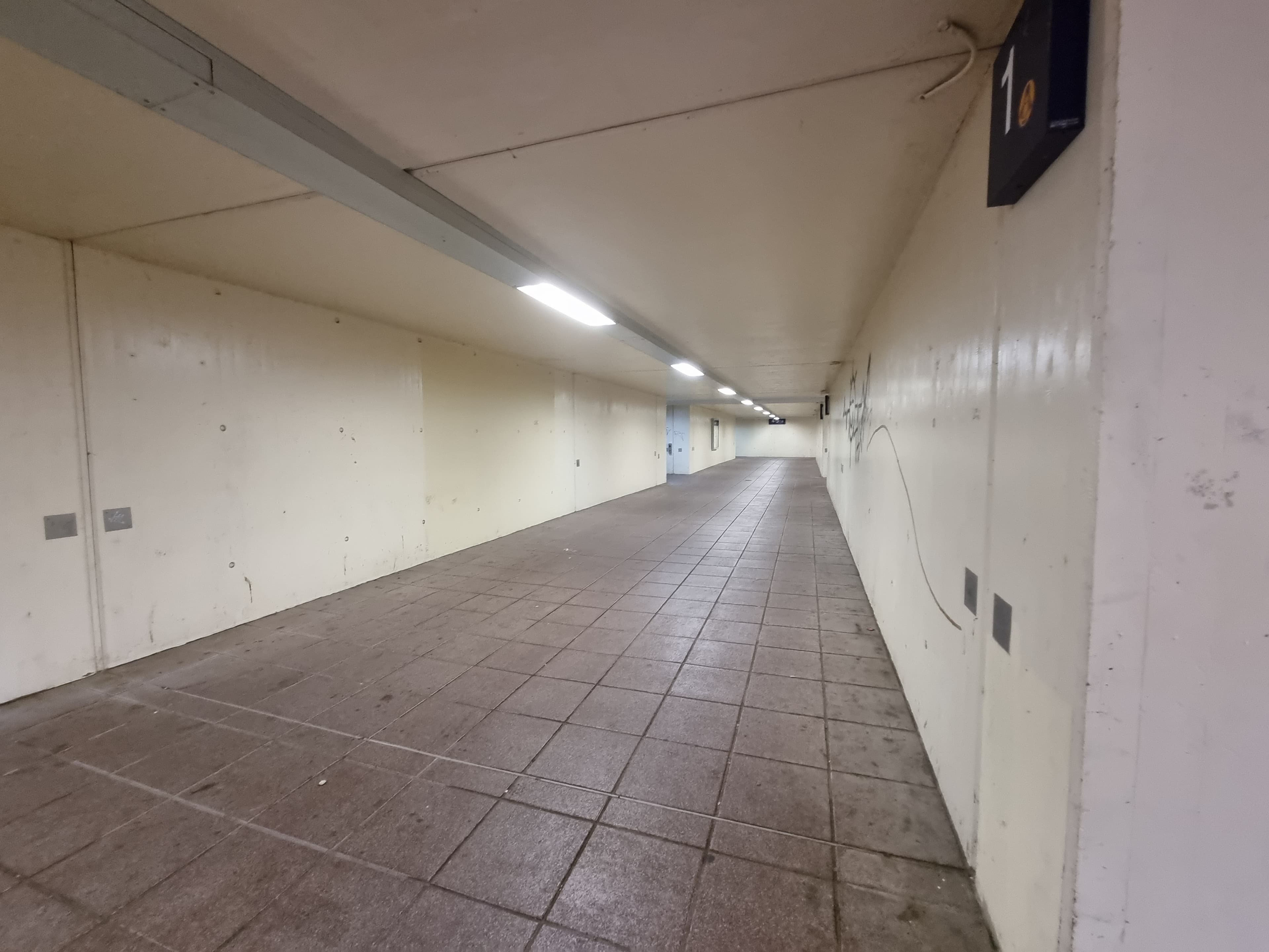 Eine Personenunterführung mit weißen Wänden.