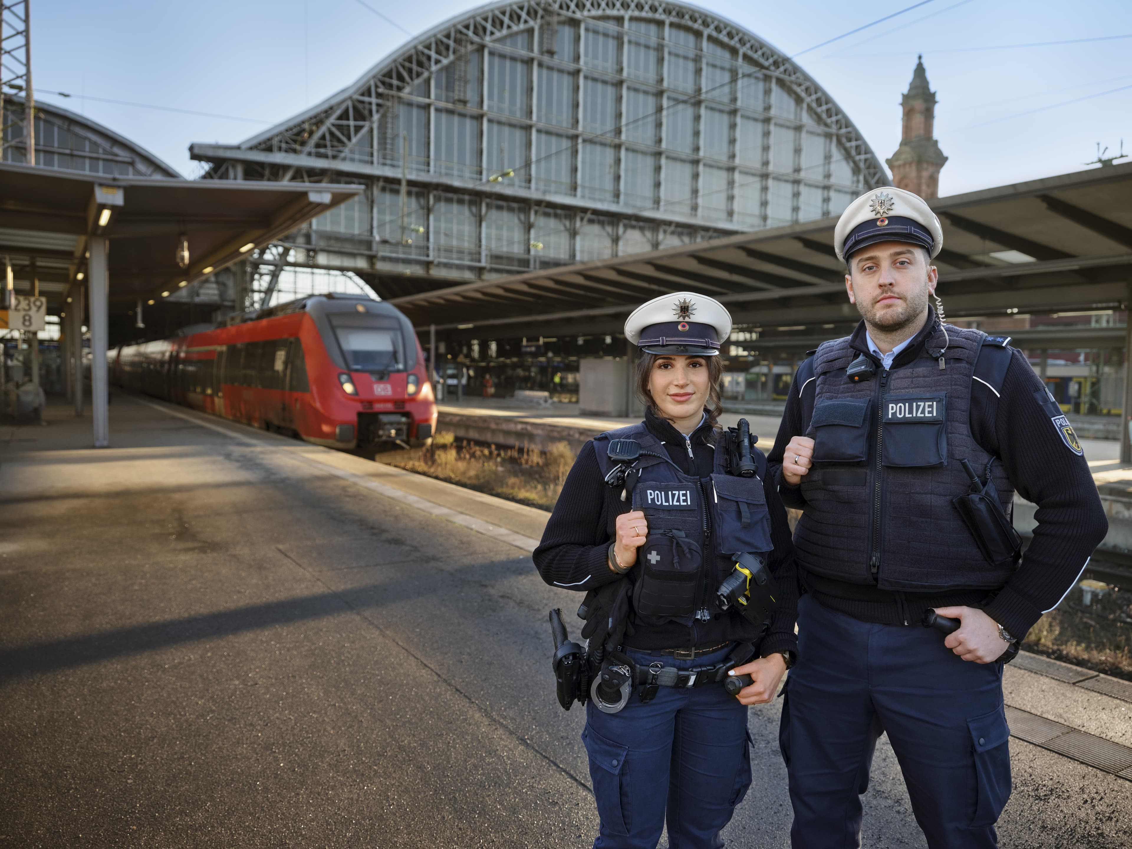 Ein Team der Bundespolizei bestehend aus einer Frau und einem Mann steht an einem Bahnsteig.