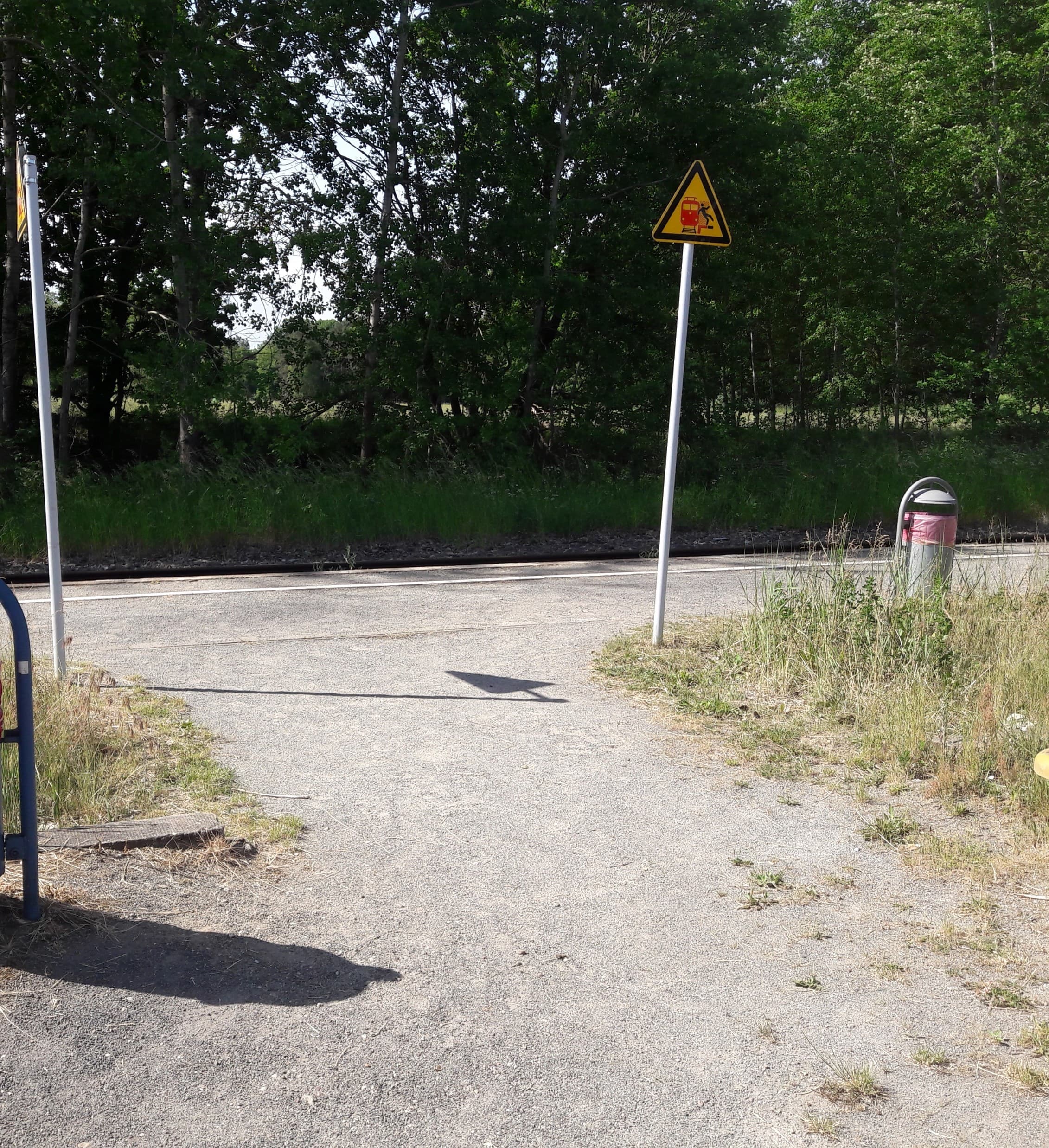 Ein unbefestigter Weg führt zum Gleis.