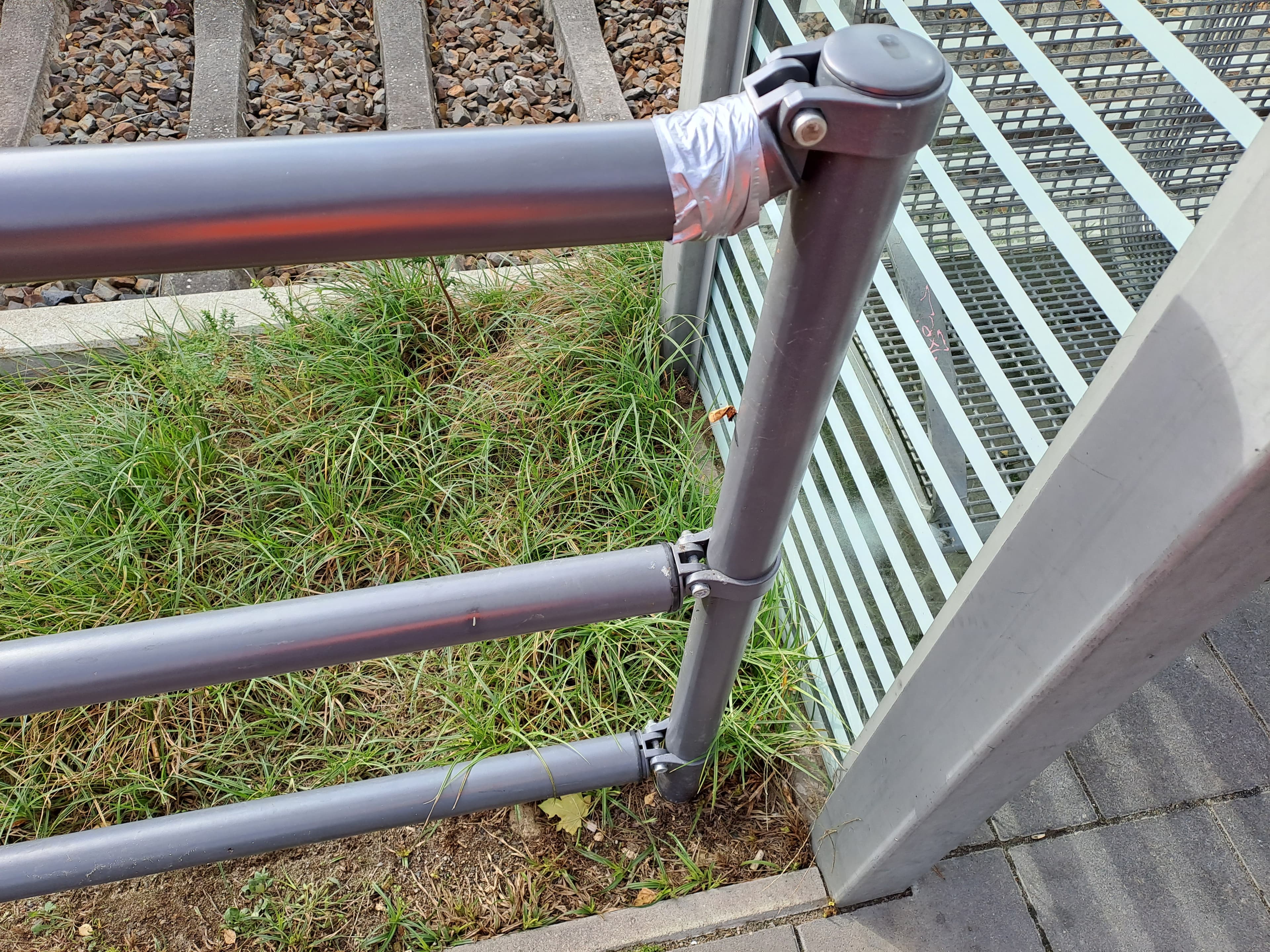 Nahaufnahme eines Geländers, mit Tape repariert.