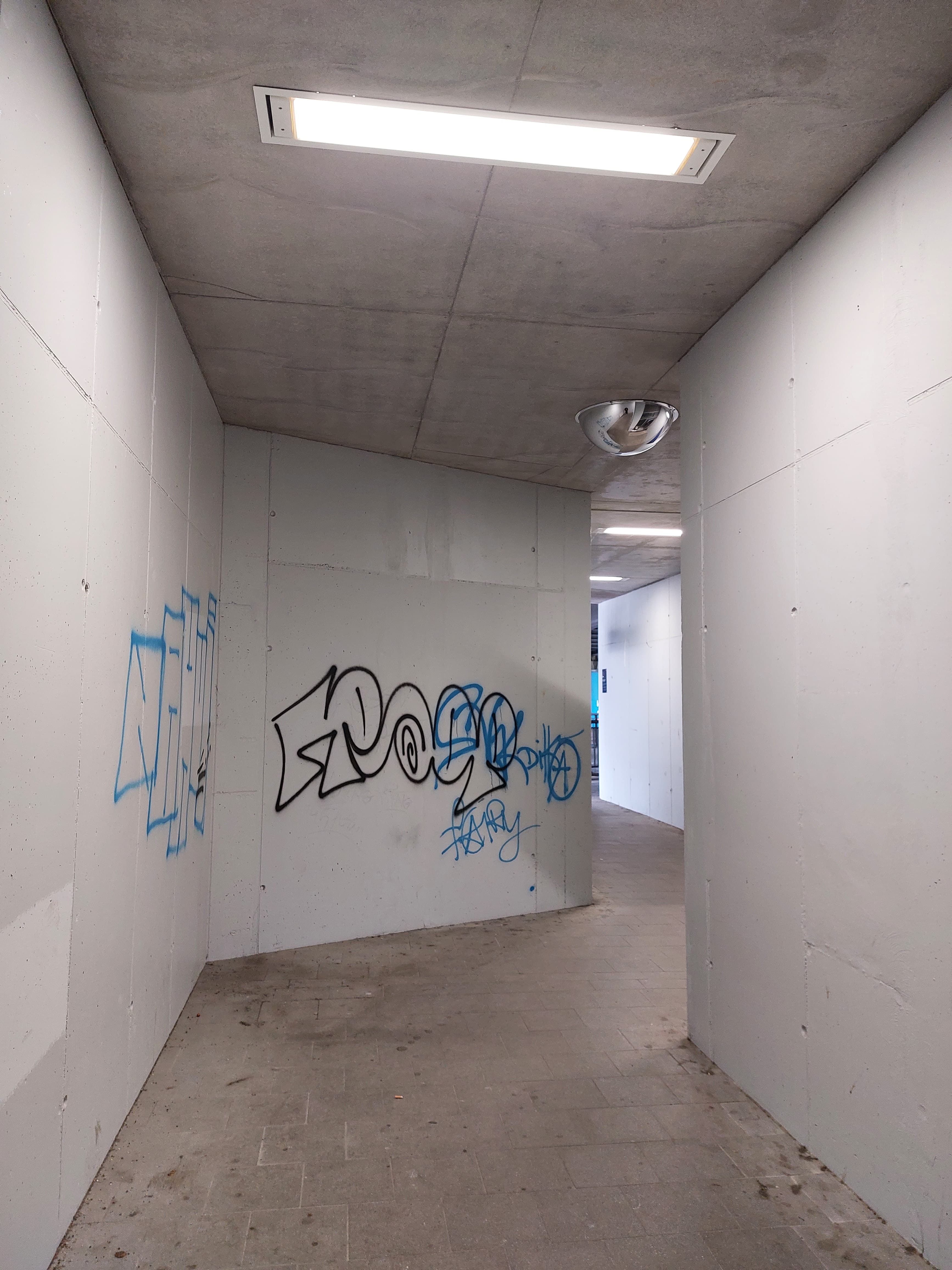 Beschmierte Sichtbetonwände im Zugangsbereich am Bahnhof, die bereits mehrmals überstrichen wurden