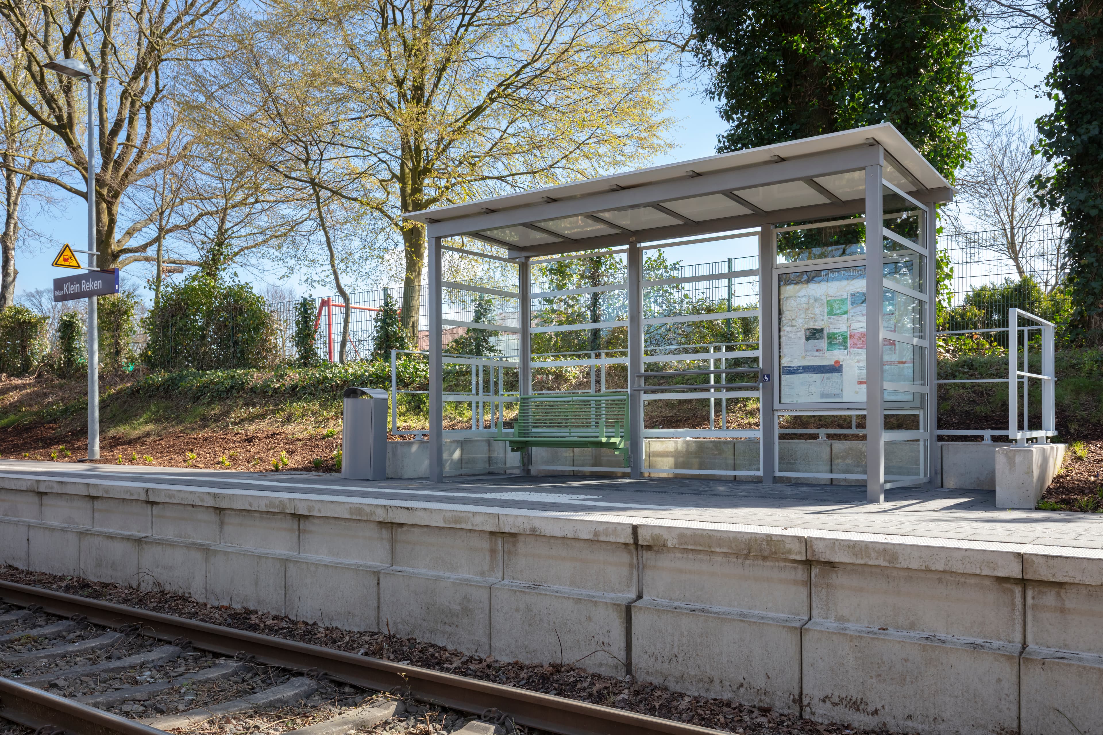 Der Blick auf den Bahnsteig mit dem Wetterschutzhäuschen mit Calidum Sitzbank und Vitrine am Bahnhof Reken-Klein Reken