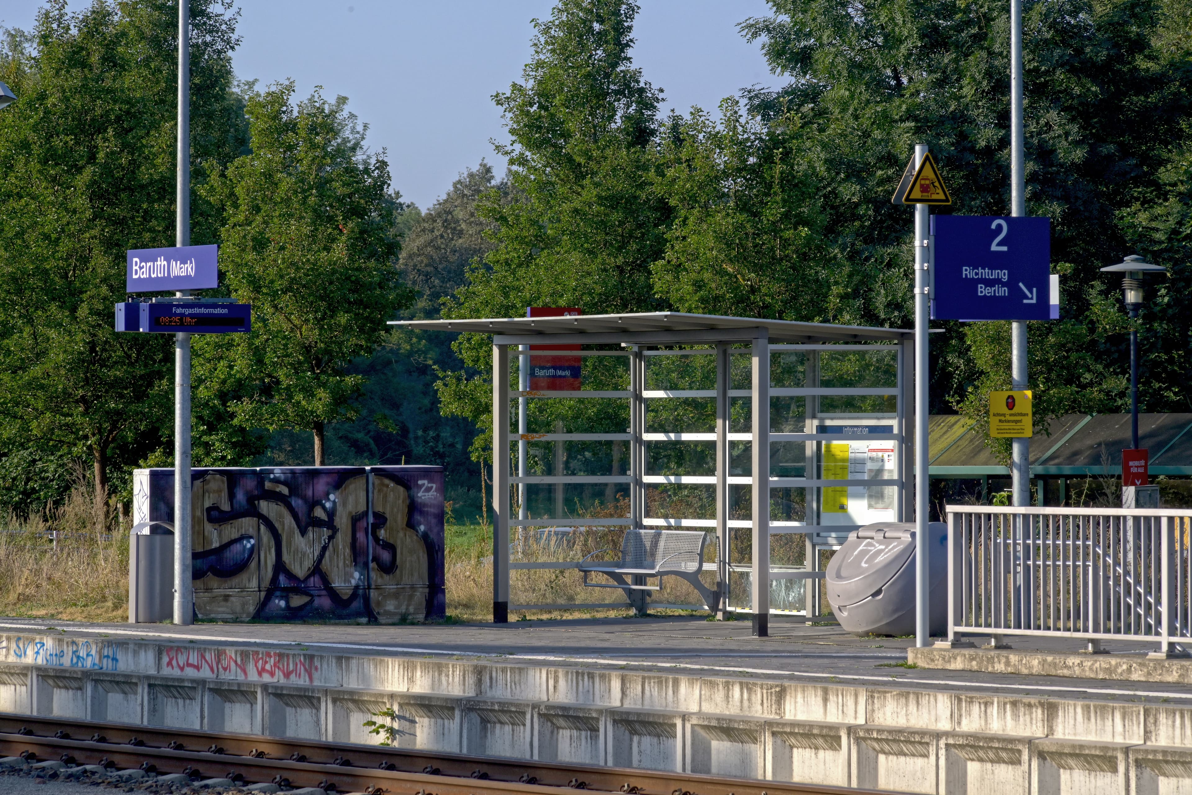 Ein Bahnsteig mit silberner Sitzbank.