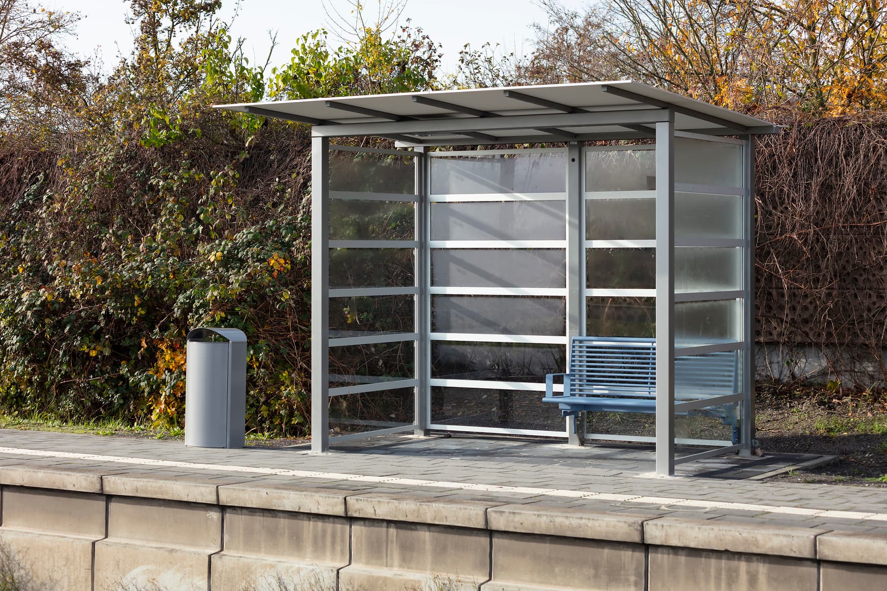 Wetterschutzhäuschen mit blauer Sitzbank. 