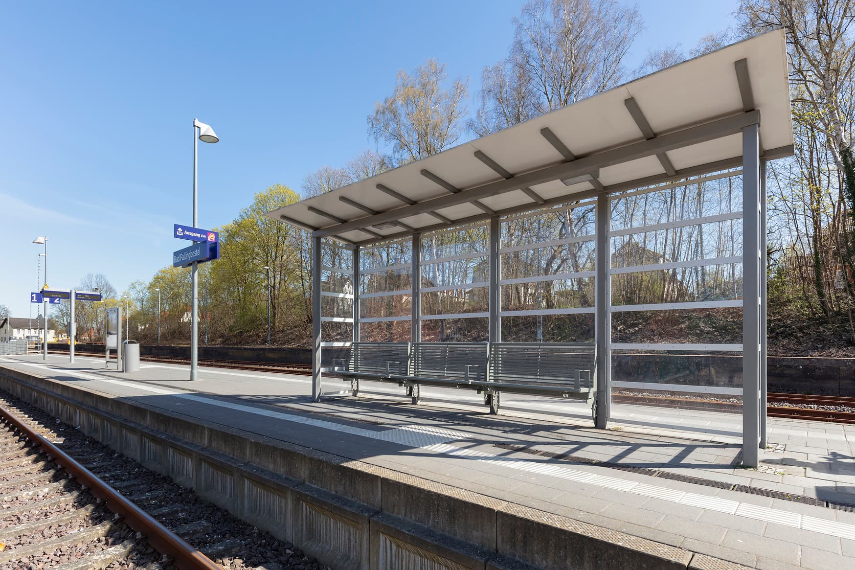 Blick auf ein Wetterschutzhäuschen auf einem Bahnsteig.