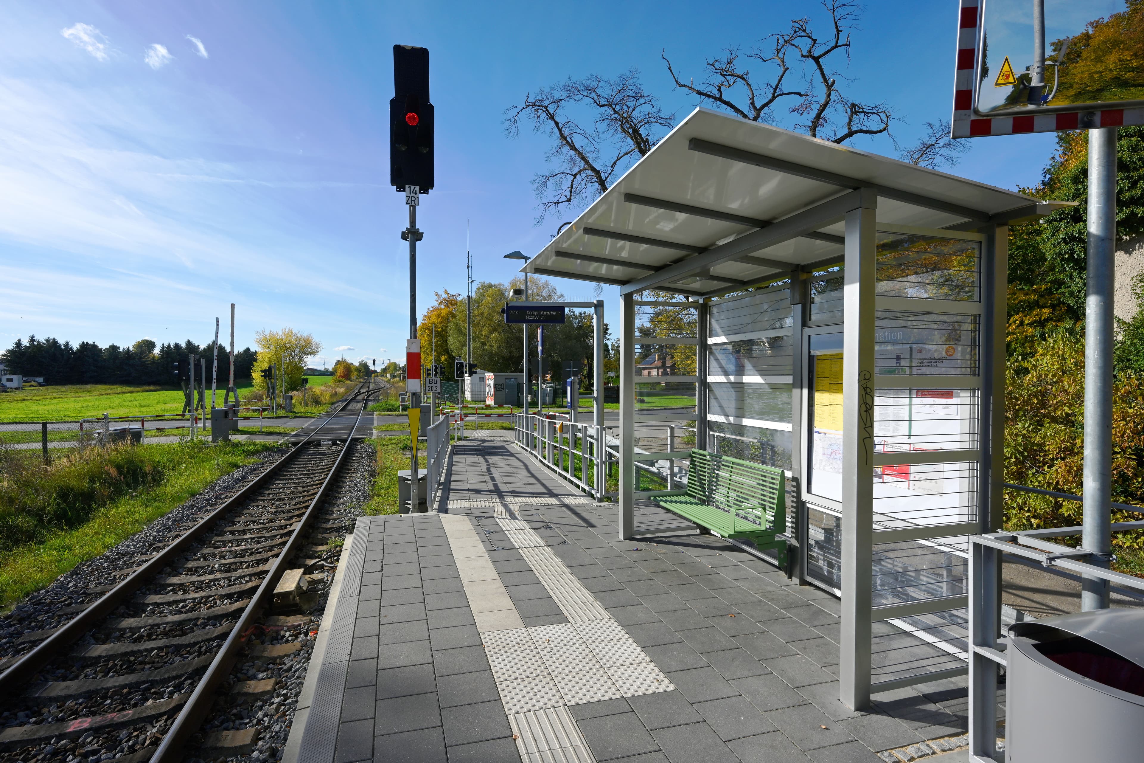 Rechts ein Bahnsteig mit Wetterschutzhaus, links Gleise.