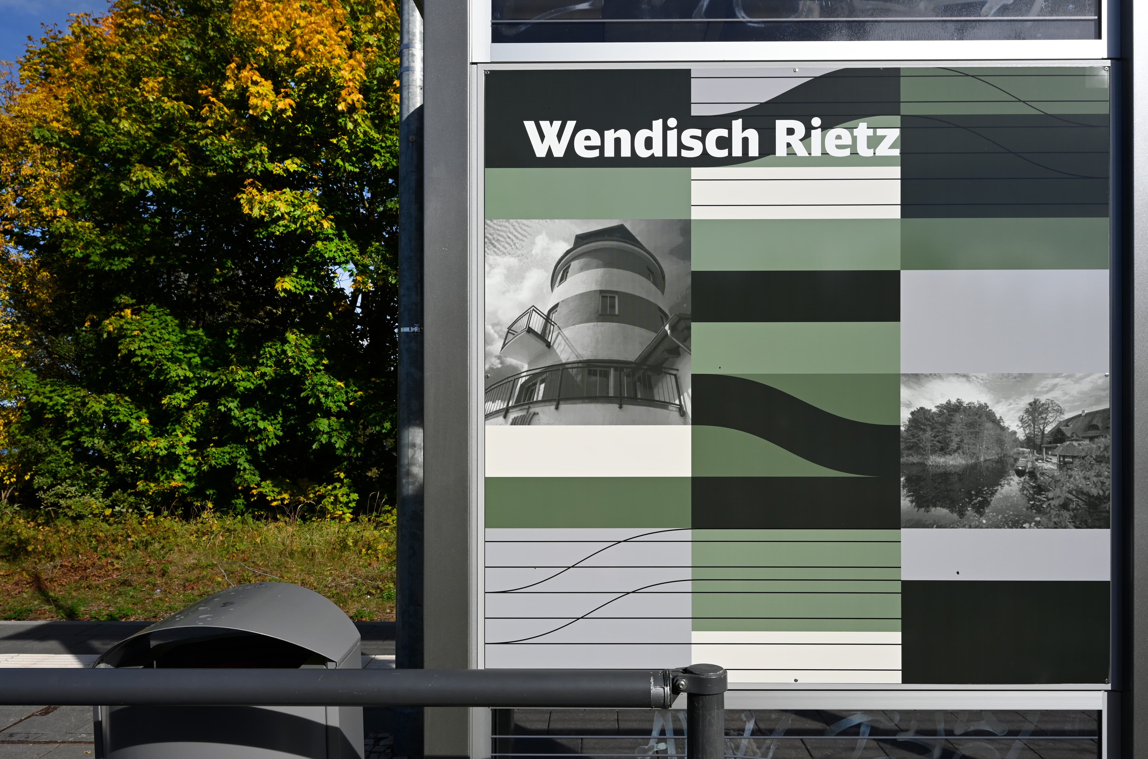 Blick auf eine grün-grau gestaltete Rückwand eines Wetterschutzhauses. 