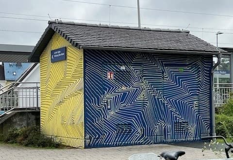 Seitlicher Blich auf das gelb-blau bemalte Stromhaus