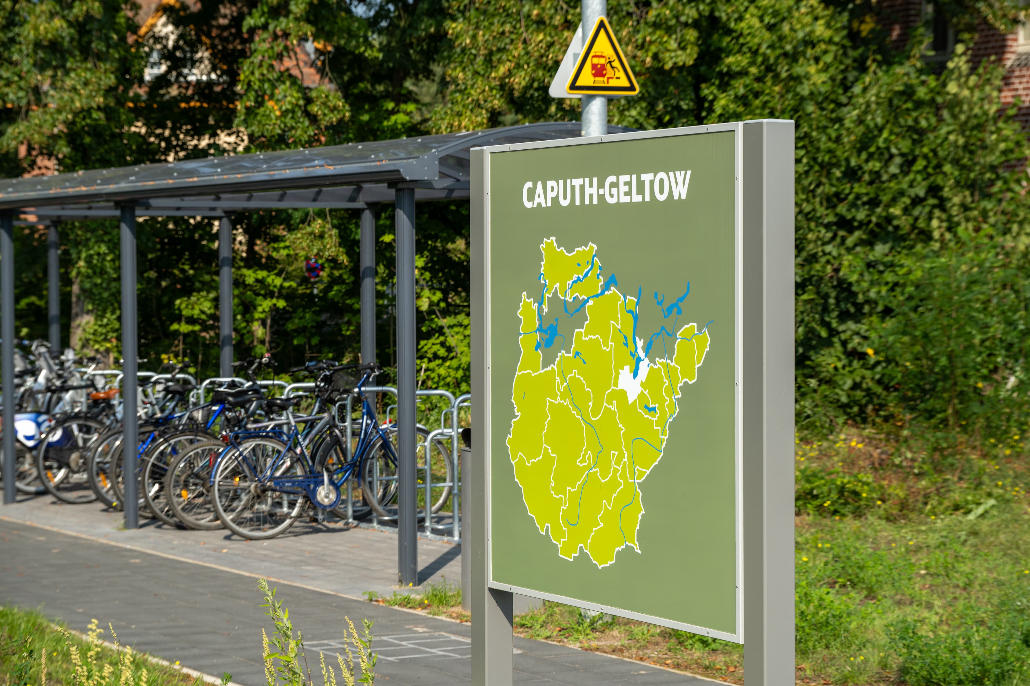 Links ein Fahrradparkhaus, rechts die Rückseite einer Vitrine mit Landkarte.