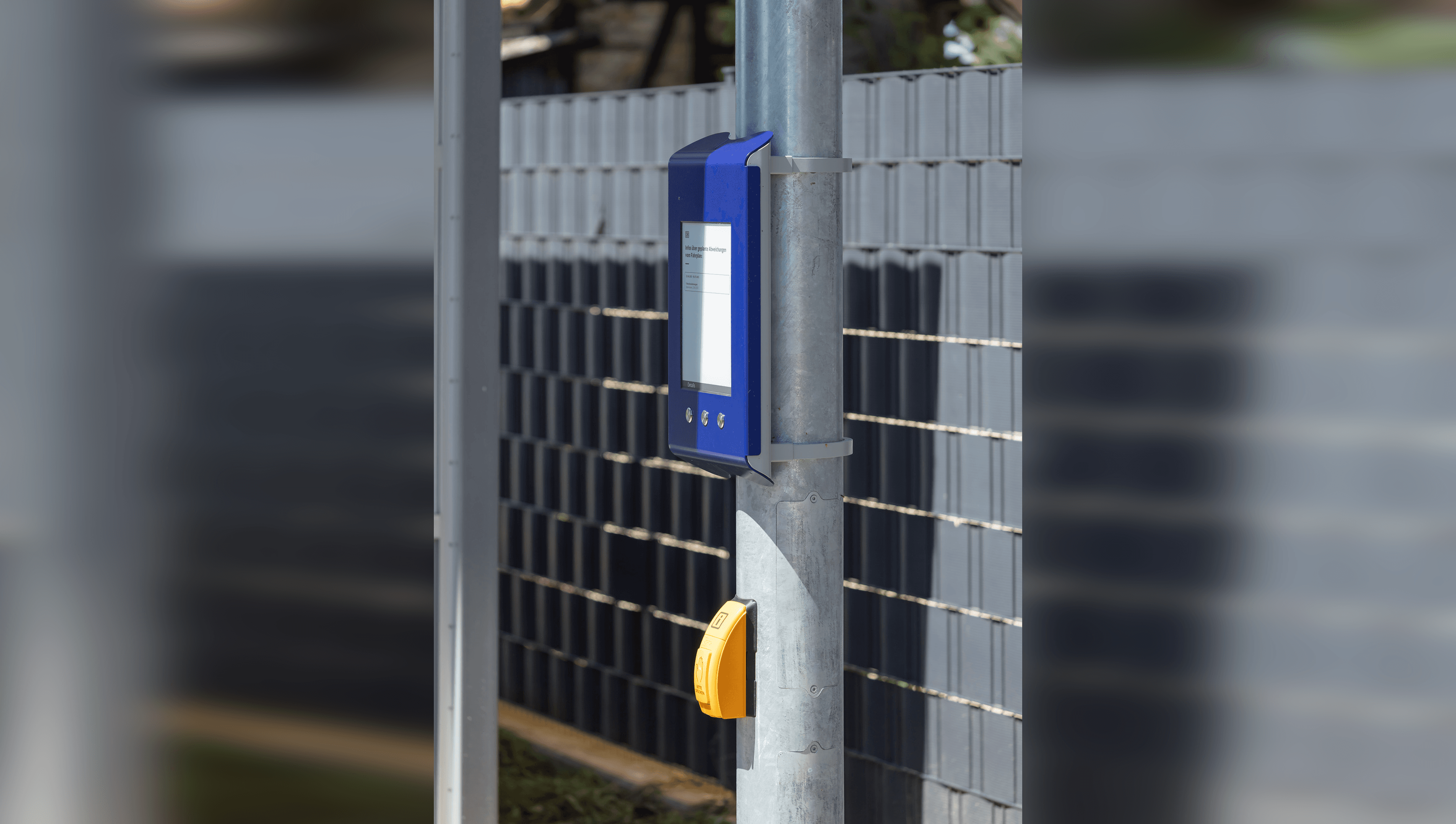 Detailaufnahme Digitaler Aushang Baukommunikation mit gelben Taster zur Akkustikausgabe.