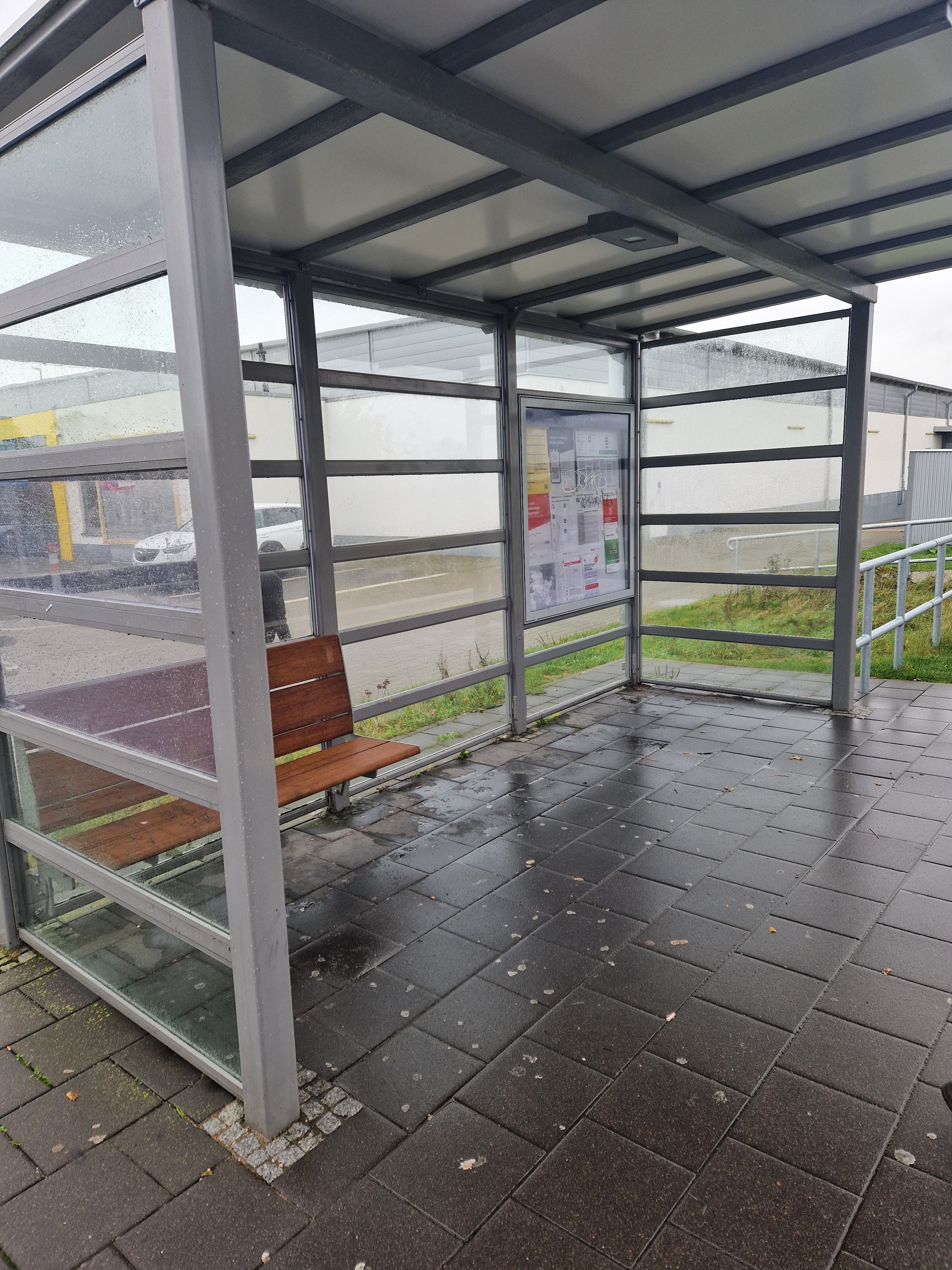 Der neue vollverglaste Wetterschutz mit Sitzbank aus Holz.
