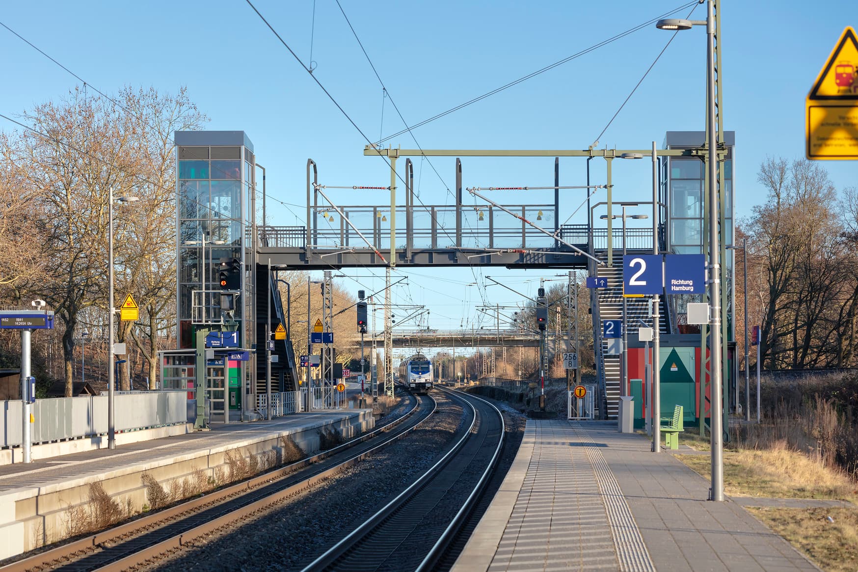 Die Fußgängerüberführung mit den gläsernen Aufzügen überspannt die beiden Gleise.