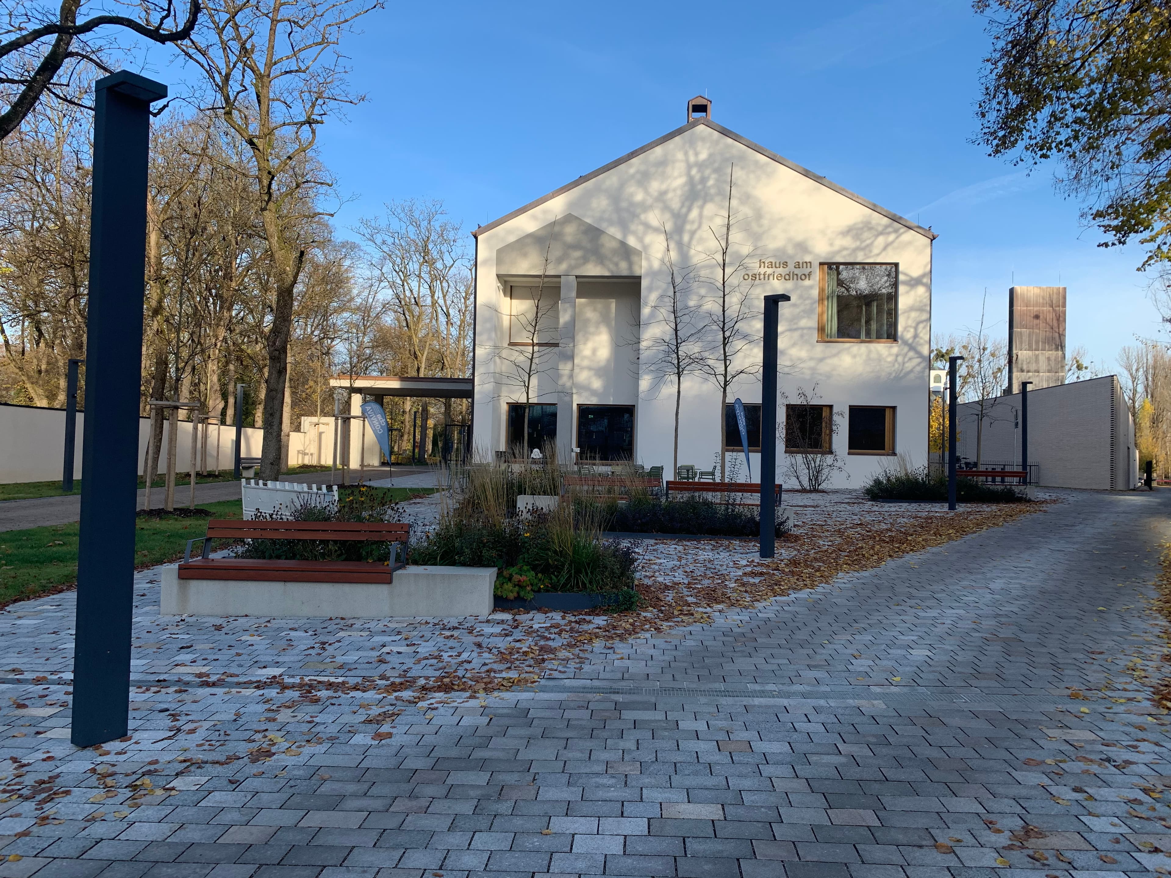 Blick auf einen gestalteten Platz mit Sitzmöglichkeiten und Begrünung.