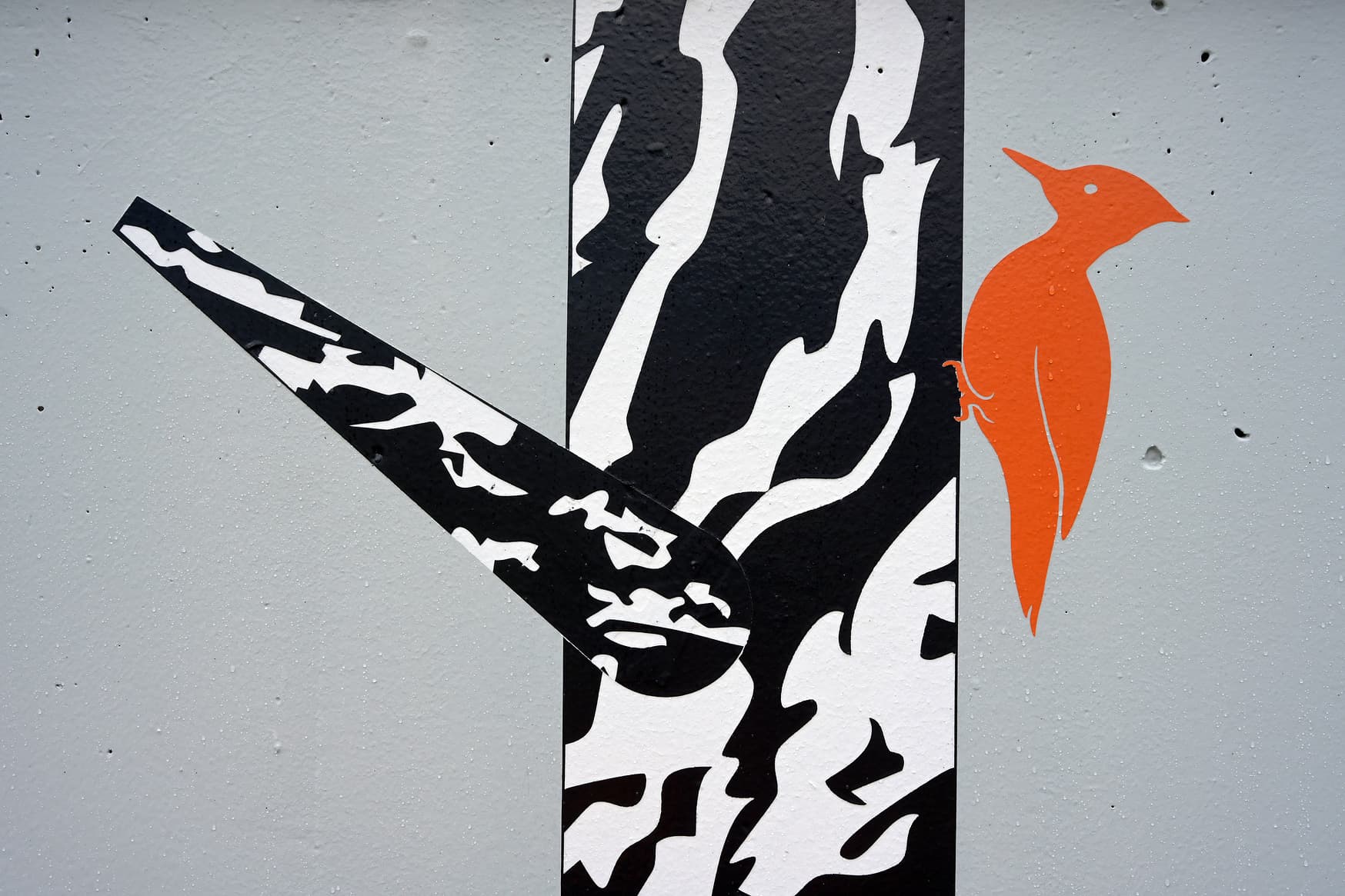 Detailansicht der Wandgestaltung. Ein schwarz-weißer Baumstamm mit rotem Specht. 