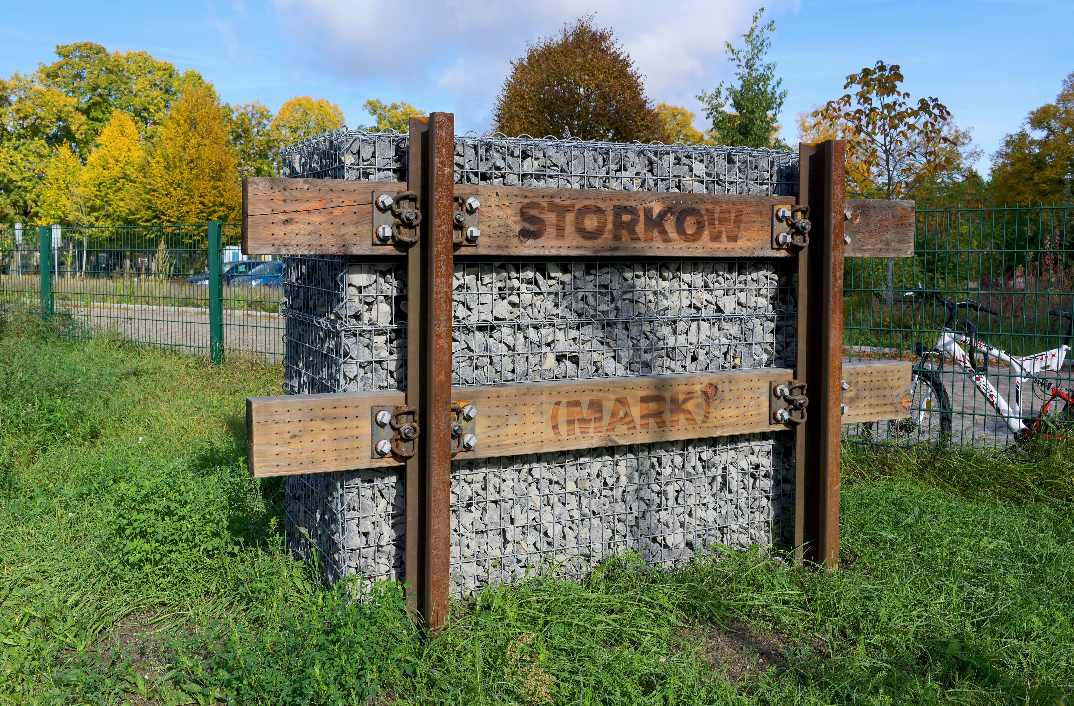 Bahnhofsschild mit Insektenhotel aus Naturmaterialien Holz und Stein.