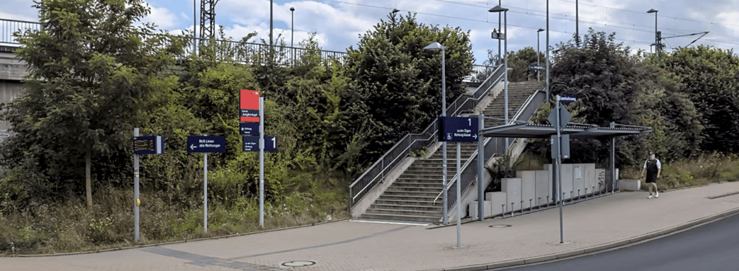 Blick auf die alte Fahrradabstellanlage. Darüber geht es eine Treppe hinauf zum Bahnsteig. 
