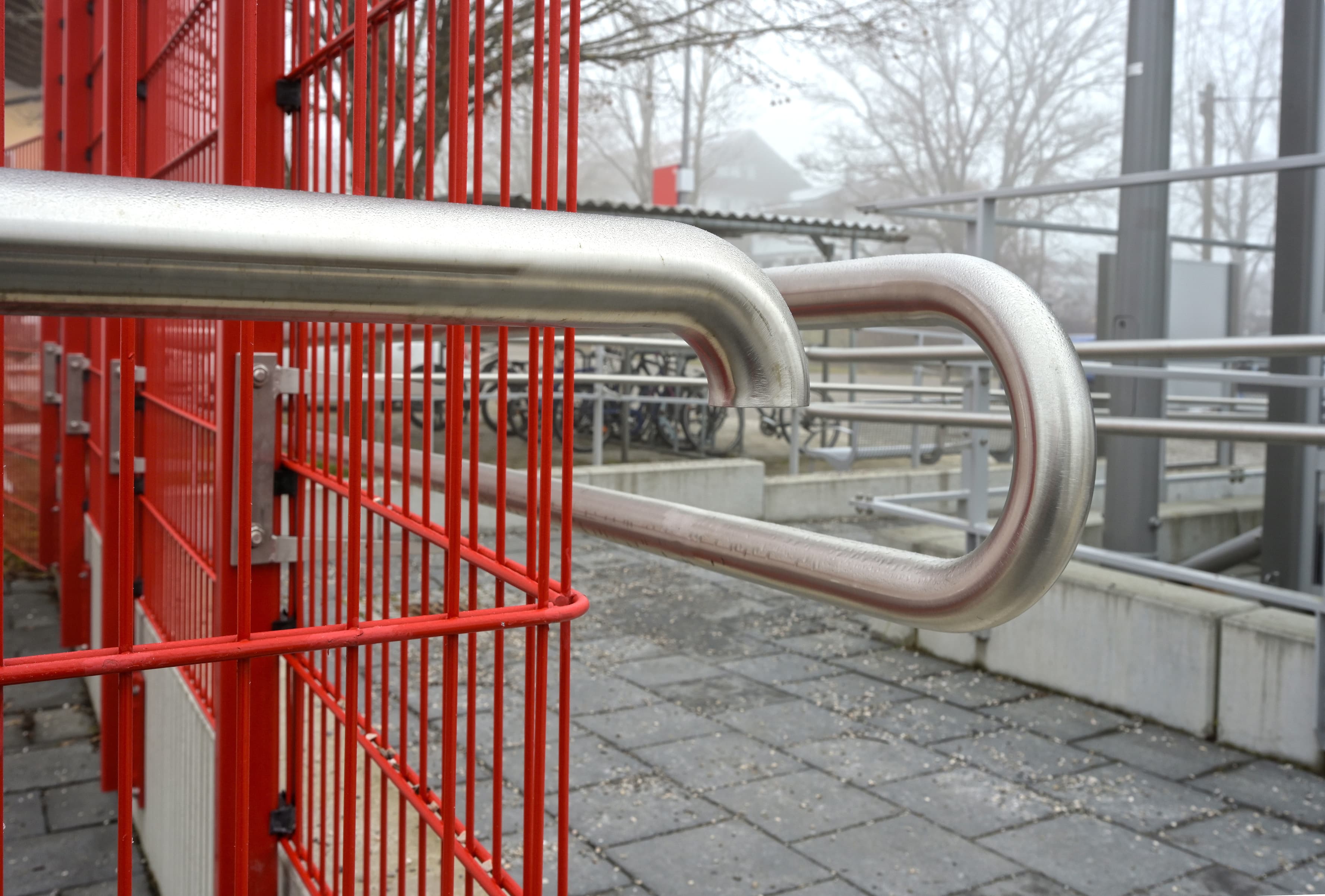 Abgebildet eine Rampe, die zum Bahnsteig des Zukunftsbahnhofs Hohenpeißenberg führt. Zudem ein Edelstahlhandlauf entlang dieser Rampe.