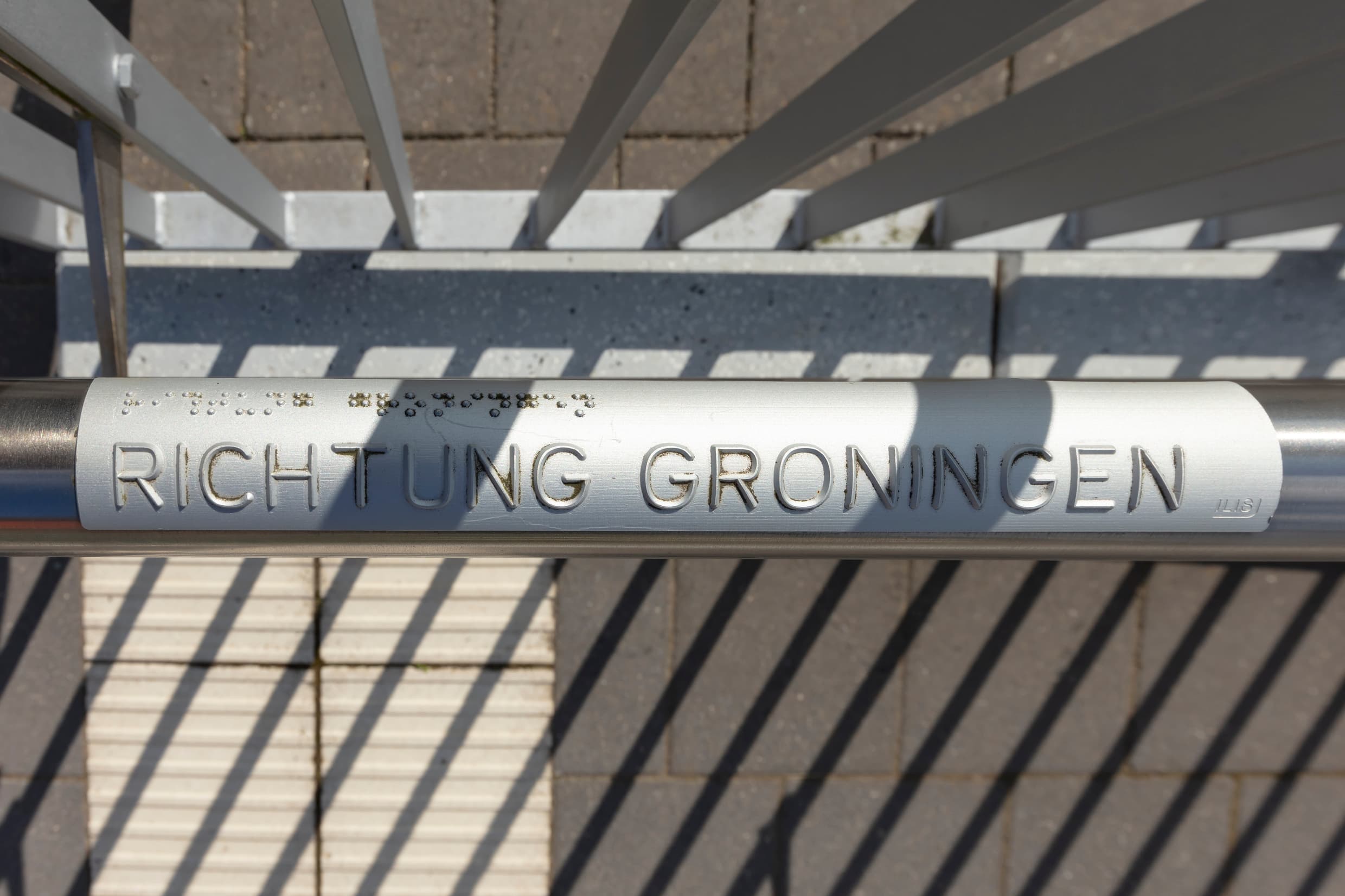  Taktiles Handlaufschild am Geländer des Bahnsteigzugangs am Bahnhof Weener.