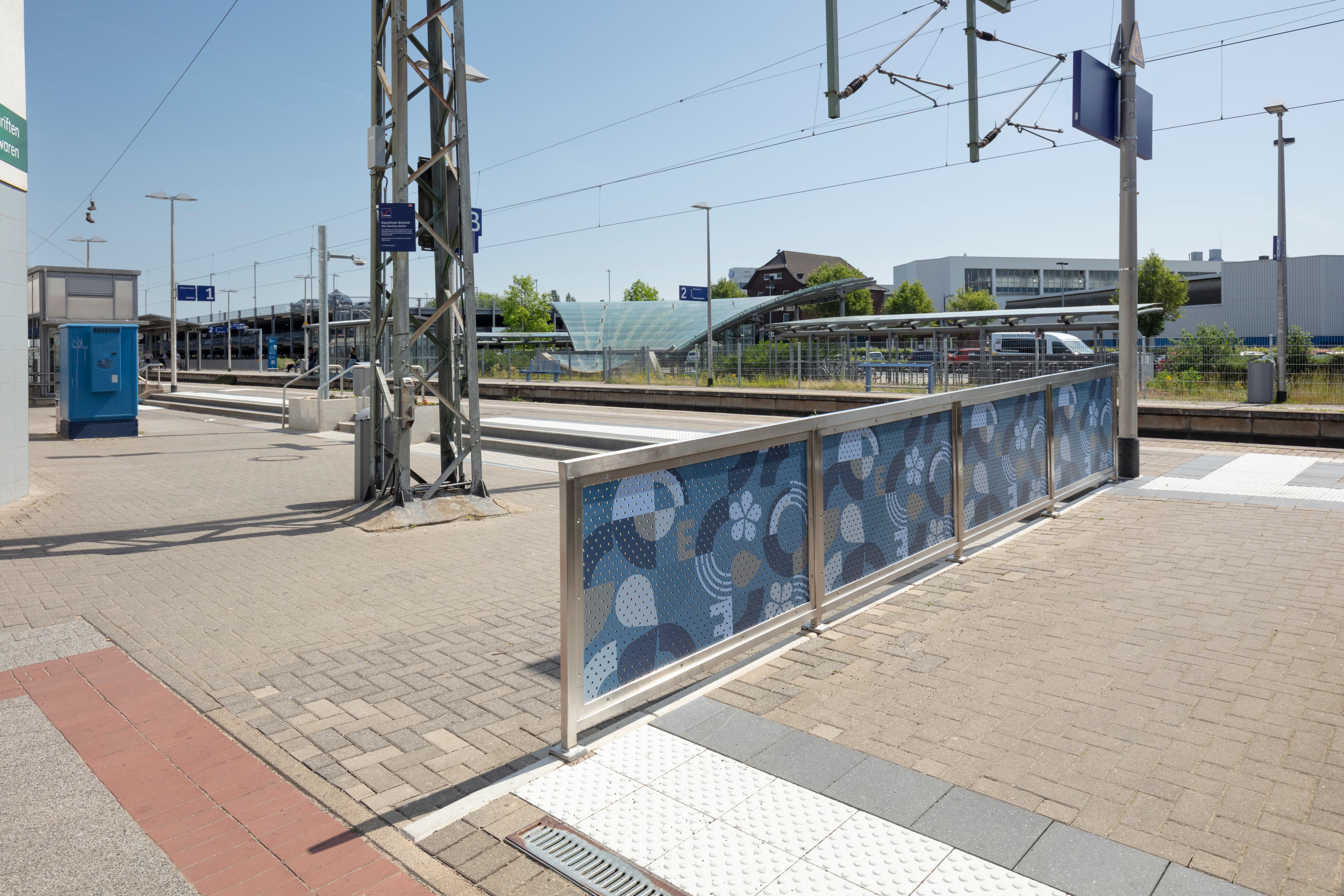 Blaues Motiv-Lochblech am Bahnhof.