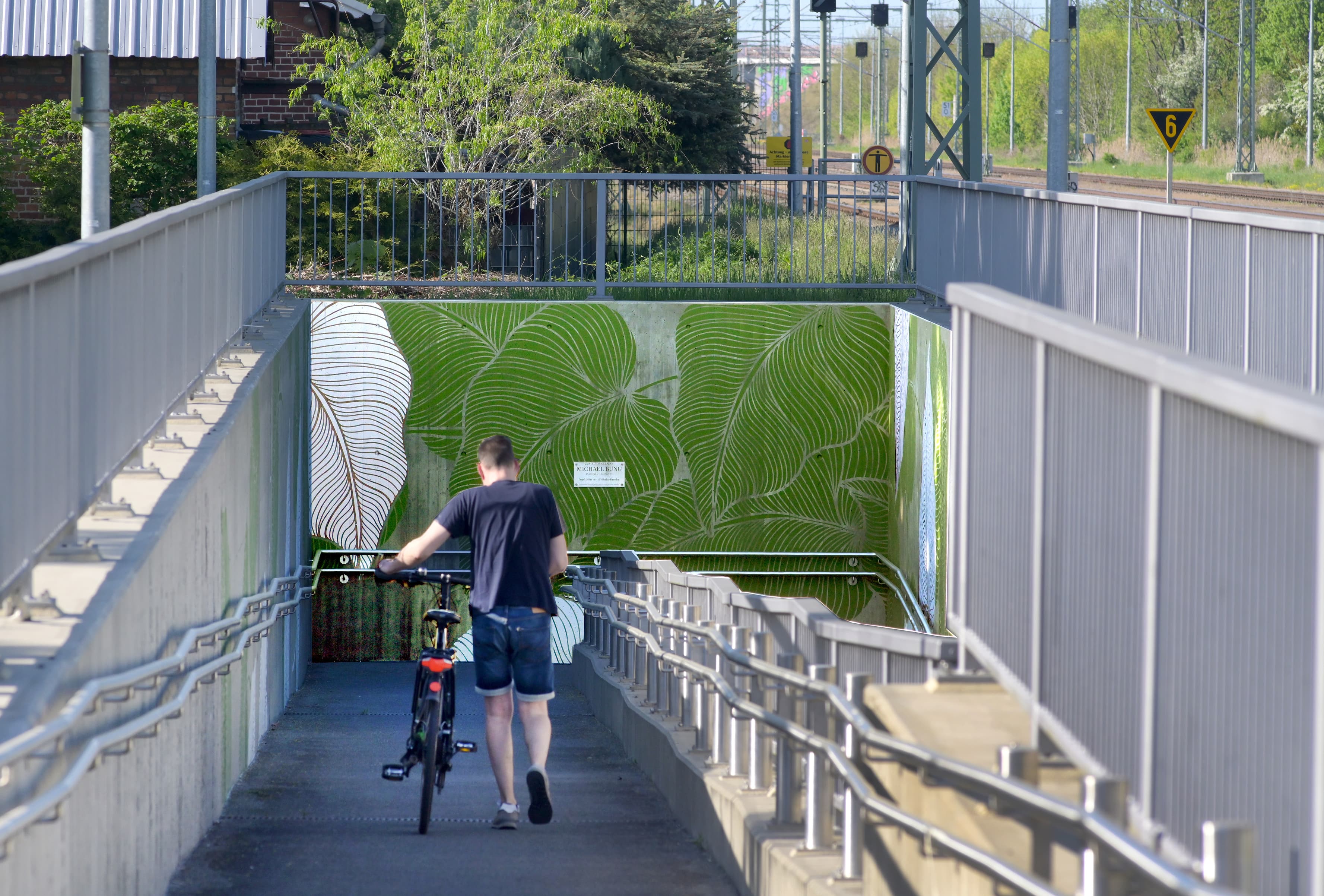 Blättermuster auf einer Wand zur Rampe der Personenunterführung. 