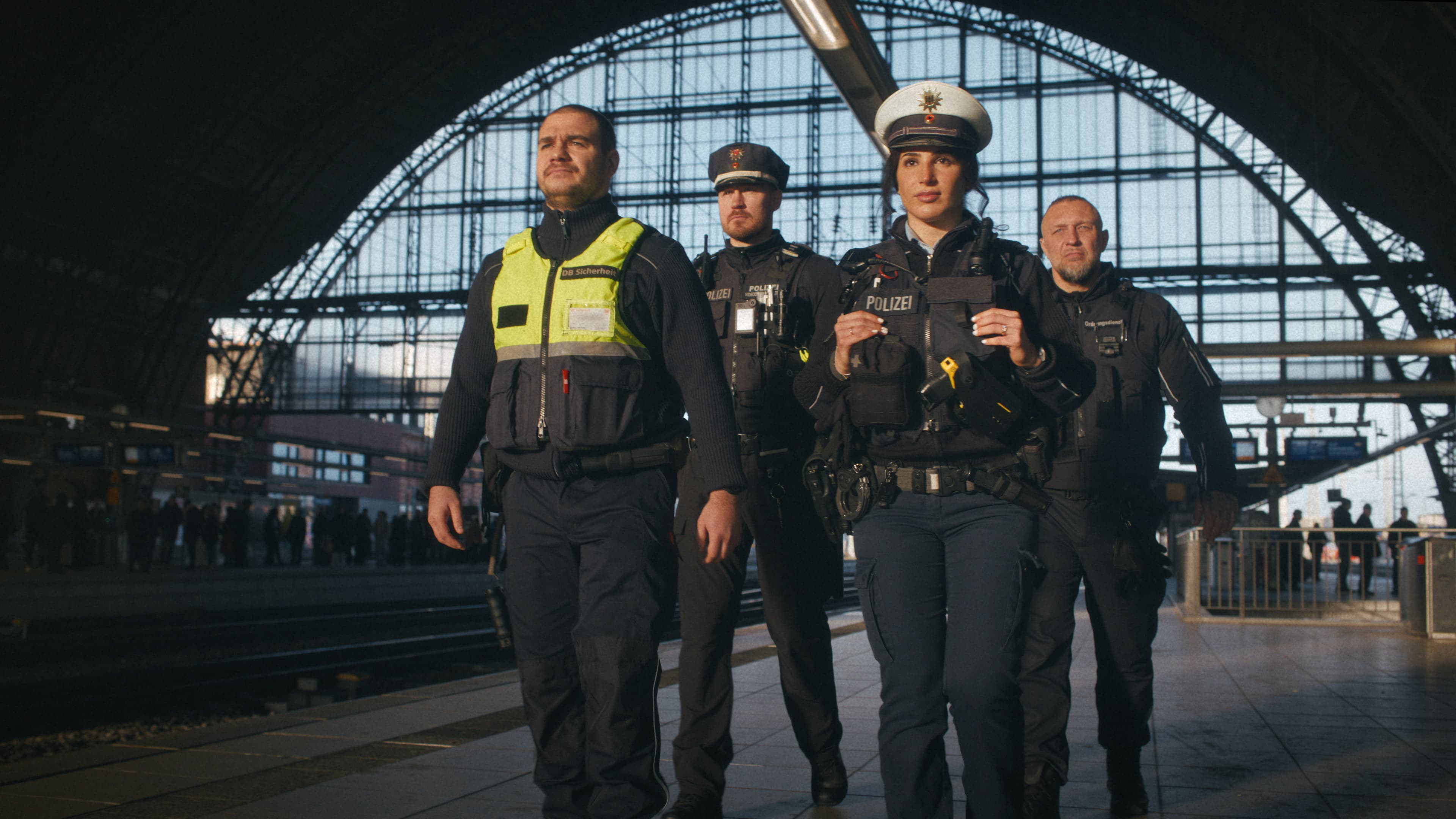Bahnhofsmitarbeitende aus verschiedenen Bereichen an einem Bahnsteig.