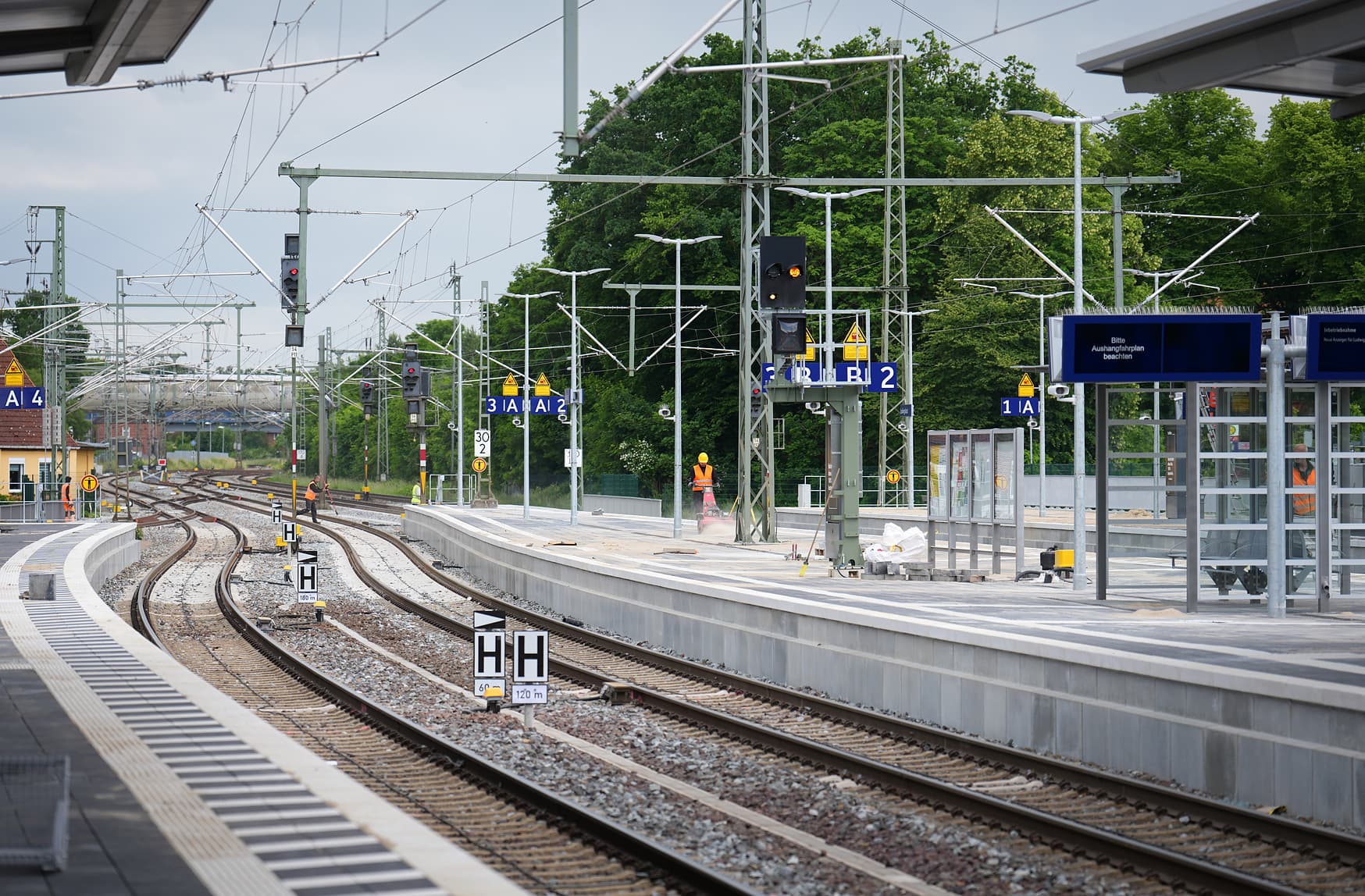 Zwei Bahnsteige mit digitalem Schriftenanzeiger.