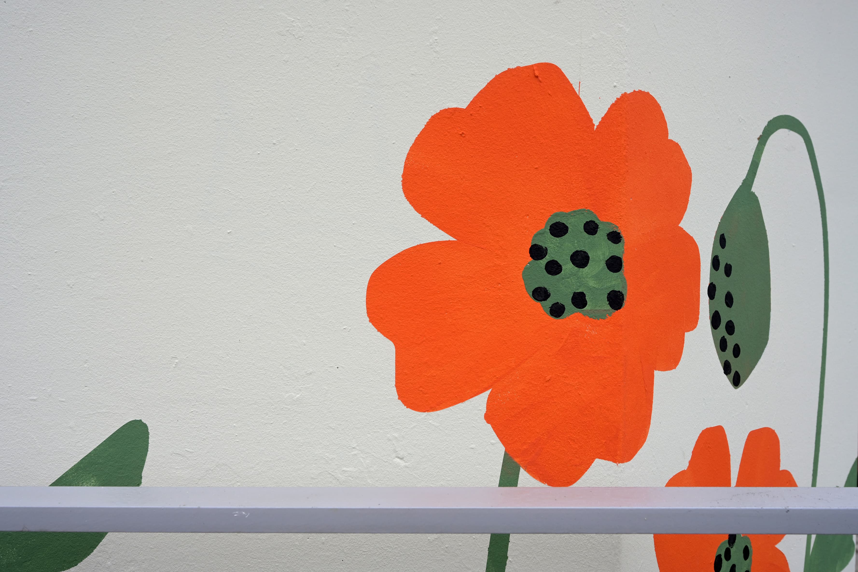  Abgebildet ein kleines Betonhaus am Zukunftsbahnhof Hohenpeißenberg, das mit gemalten Blumen künstlerisch gestaltet wurde.