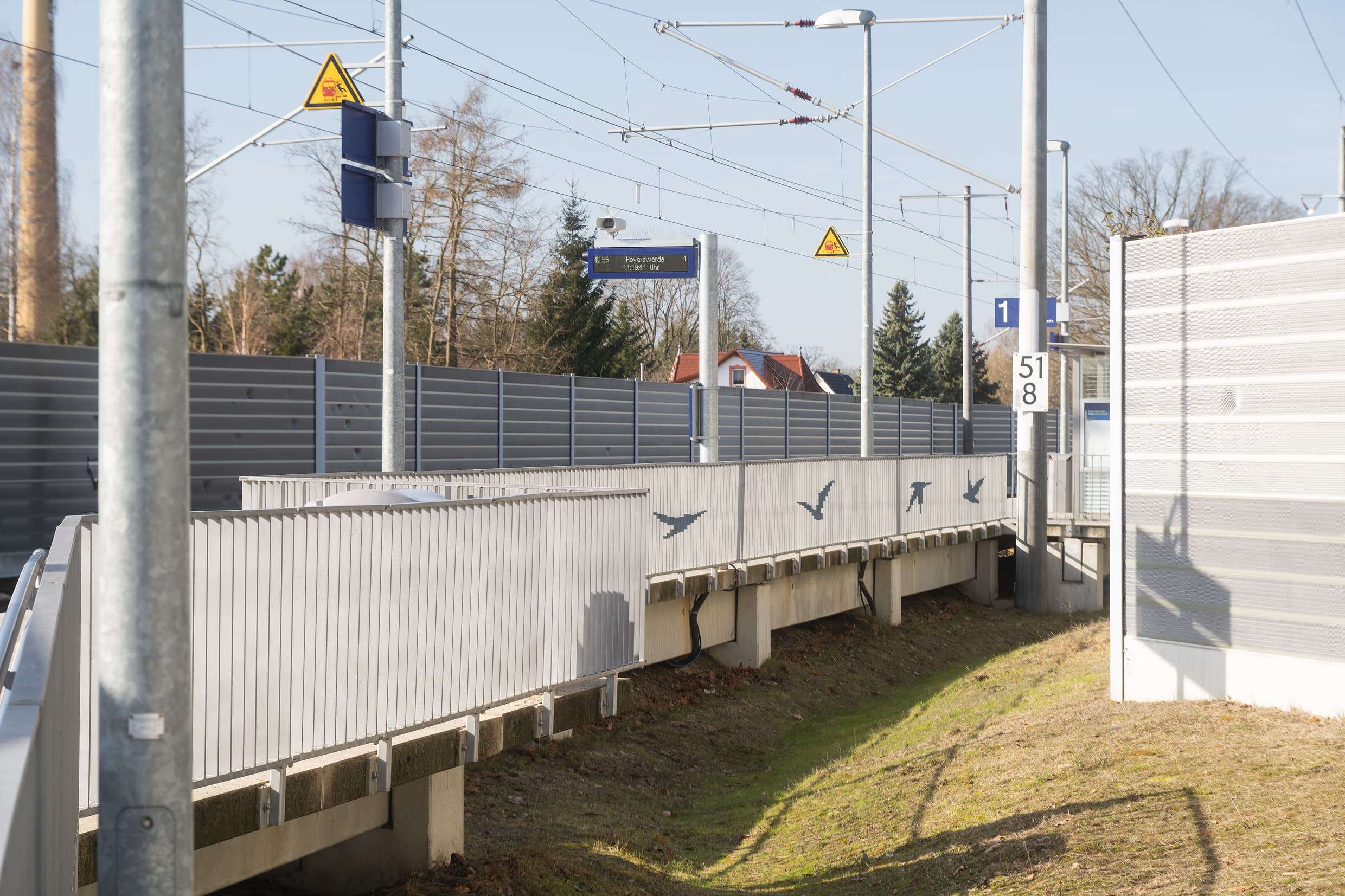 Geländer mit aufgebrachten Vogelmotiven. Hinter dem Geländer ist noch der zweizeilige Anzeiger zu sehen.