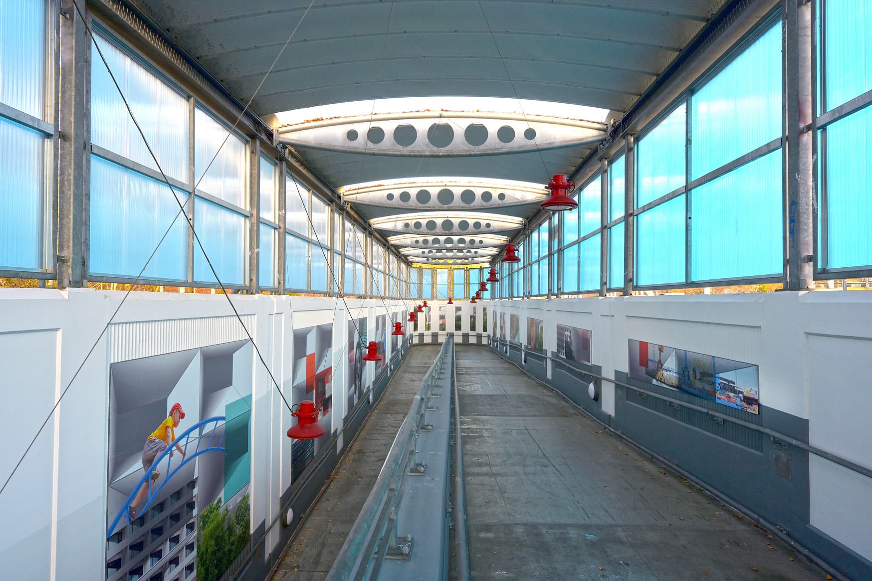 Fahrradrampe mit roten Lampen und künstlerische, gestalteten Wänden.