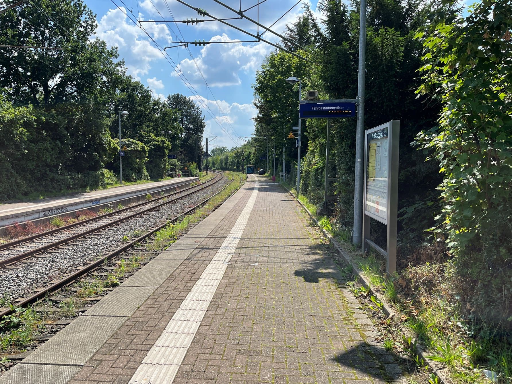 Blick auf einen Bahnsteige mit alter Fahrgastinformationsanlage (DSA). Daneben befinden sich die Gleise.