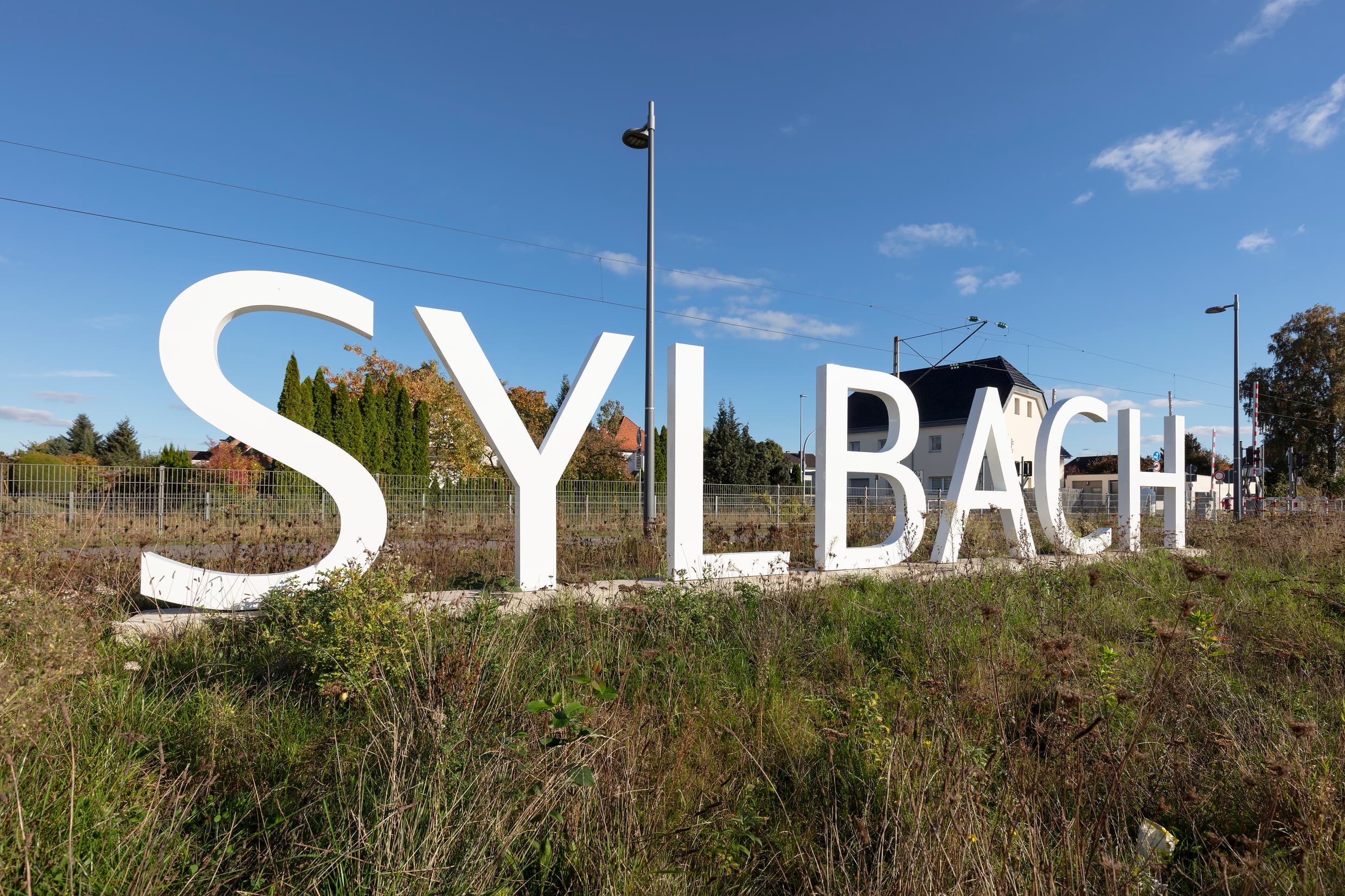 Personengroßer Schriftzug in weiß mit dem Text "Sylbach".