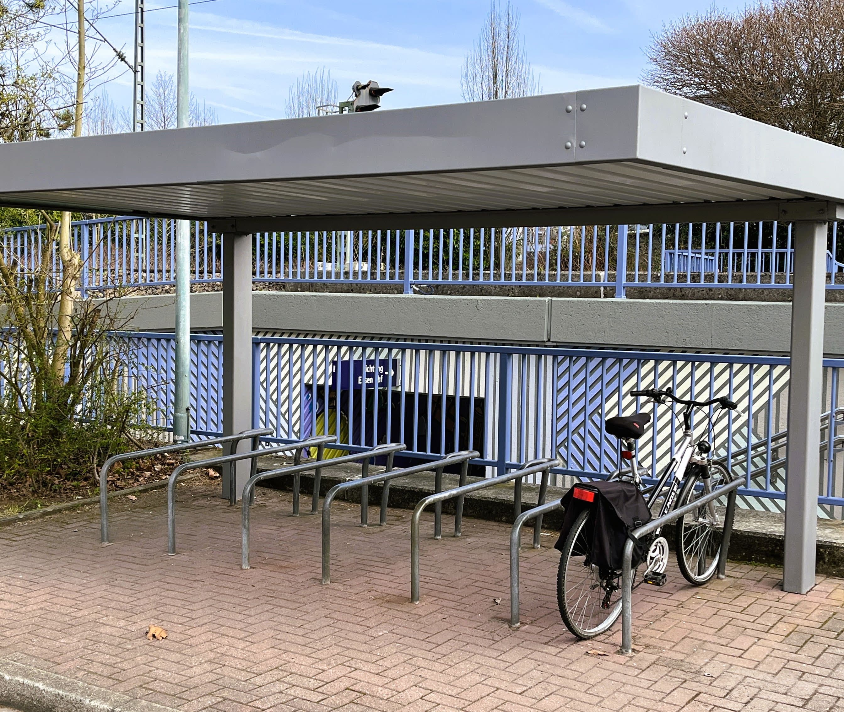 Neu gestrichene Fahrradabstellanlage. Darunter parkt ein Fahrrad.