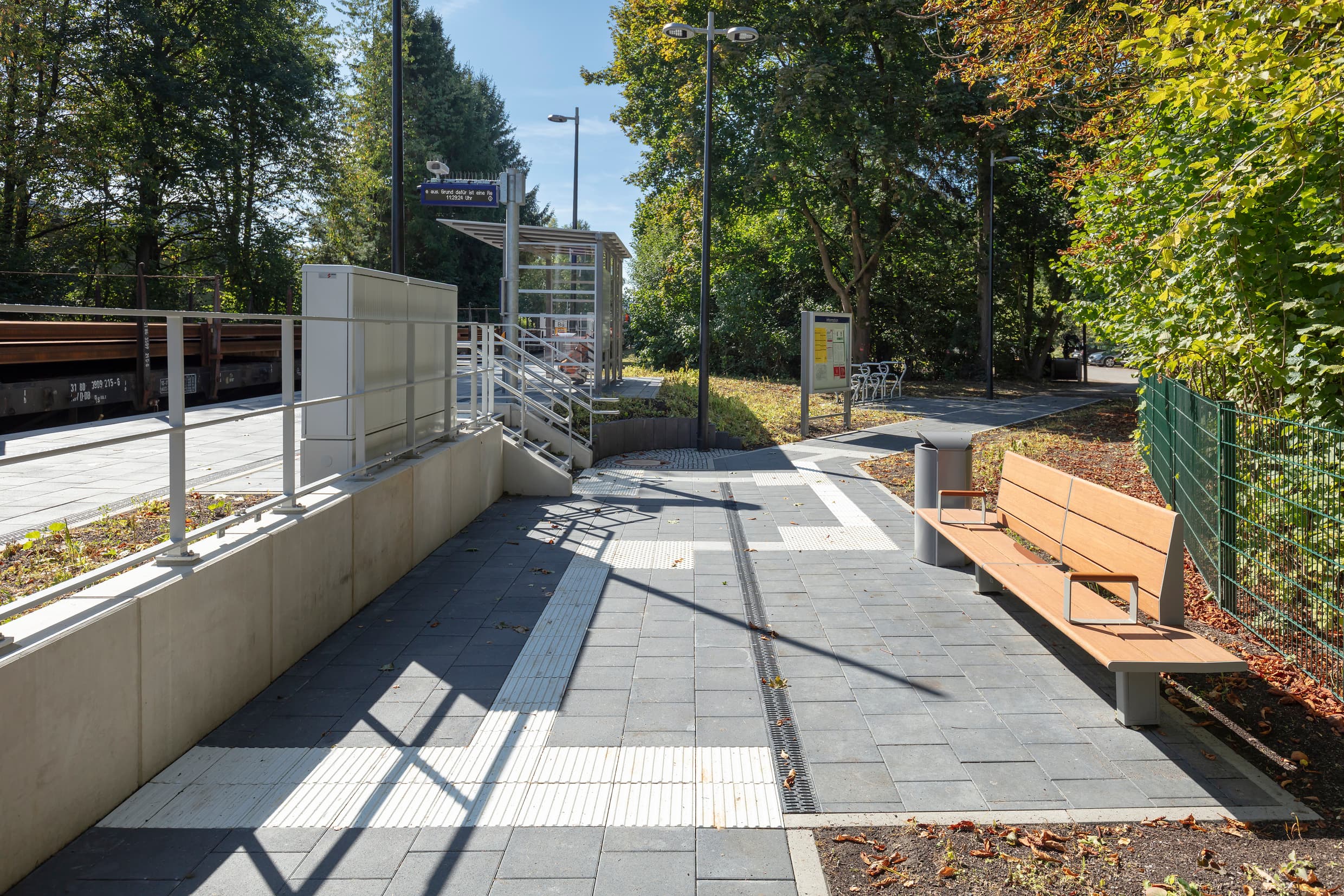 Im Zugangsbereich zum Bahnsteig steht eine Sitzbank aus Holz.