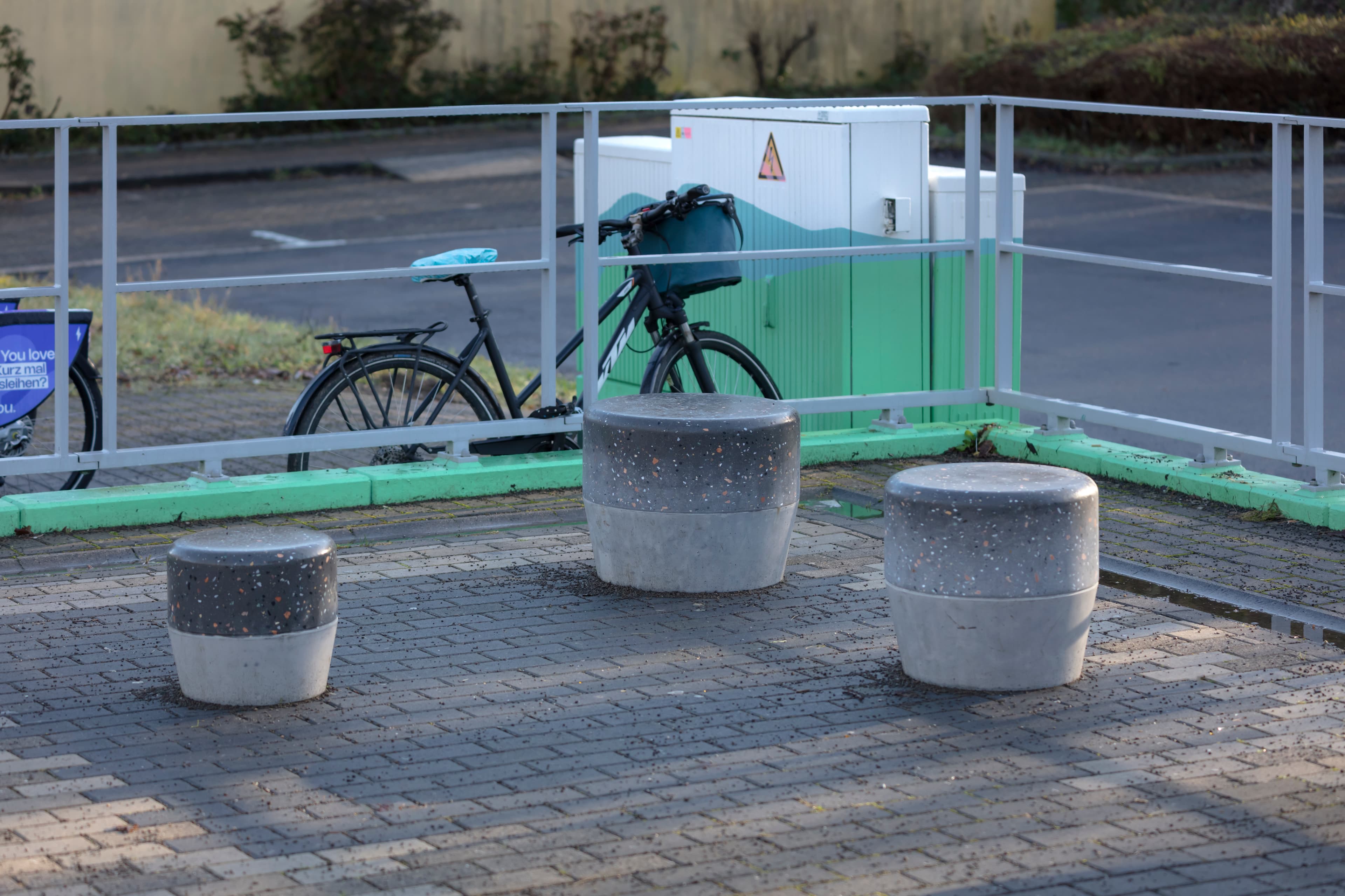 Blick auf drei neue Hocker am Bahnsteig.