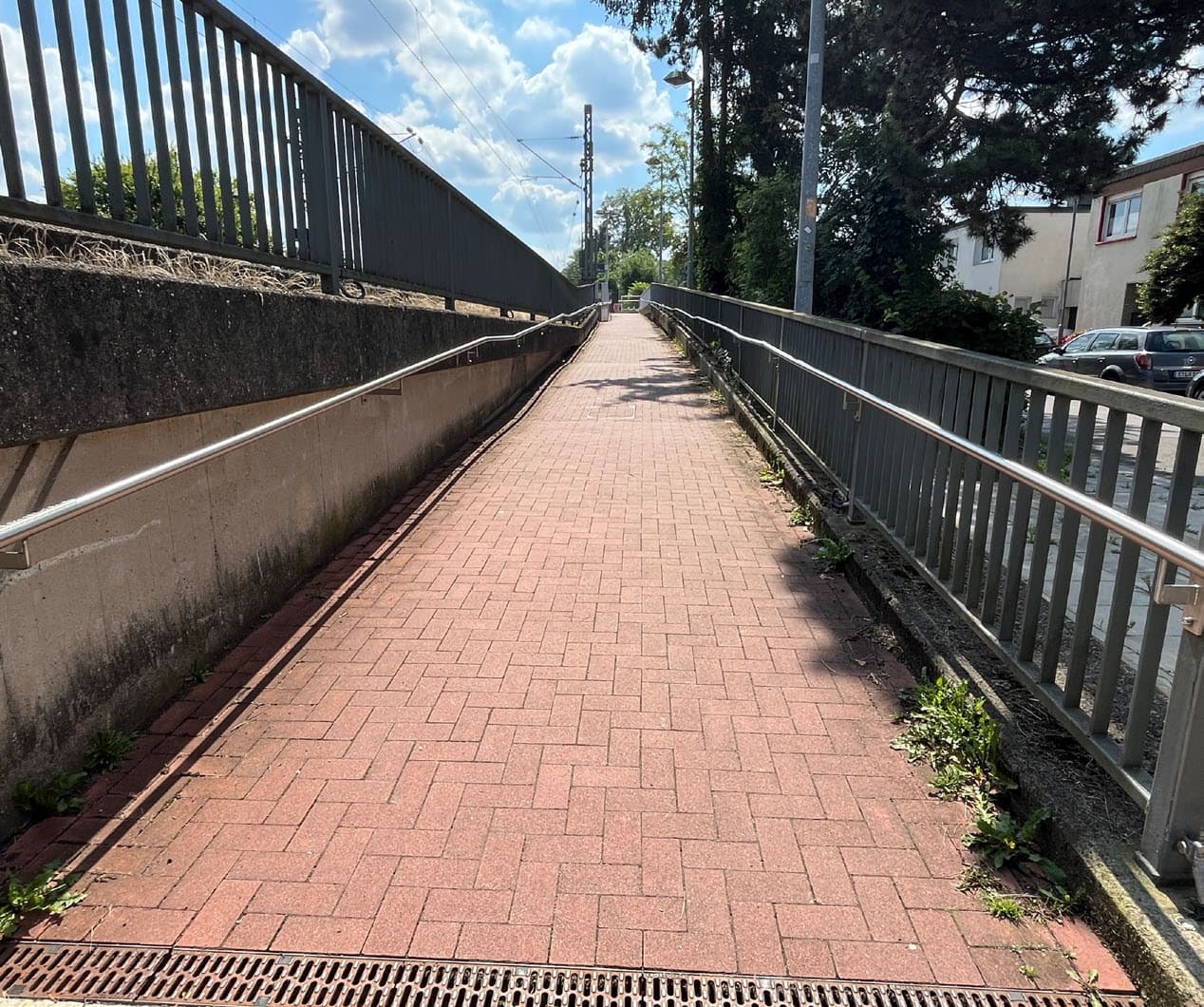 Blick auf einen Zugang zum Bahnsteig. Rechts und links Handläufe.