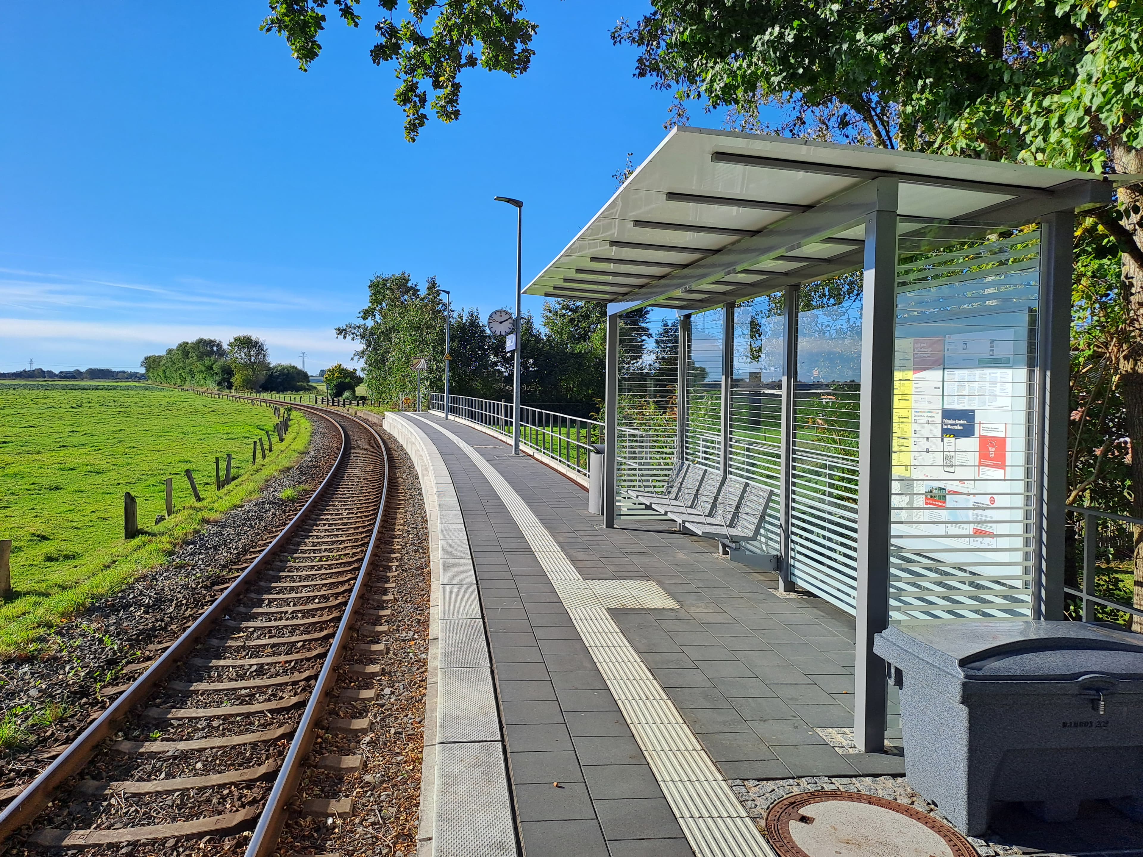 Der modernisierte Bahnsteig mit dem gläsernen Wartehaus inklusive Sitzgelegenheiten. Im Hintergrund die neue Bahnsteiguhr.