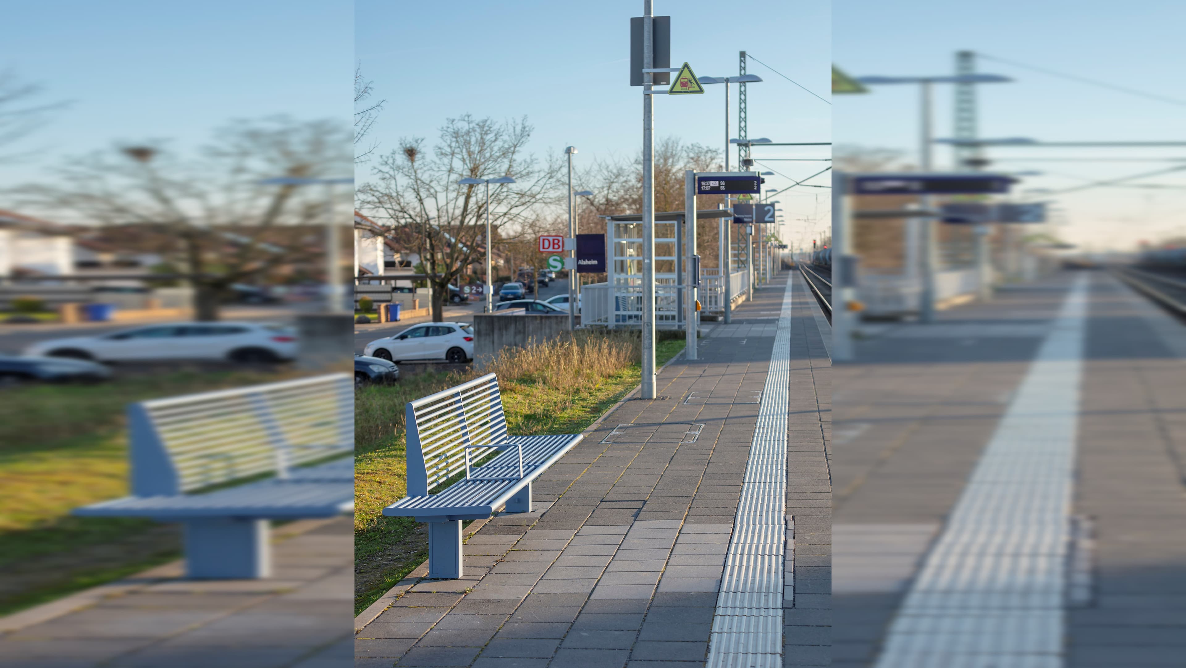 Modernisierter Bahnsteig mit neuer Sitzbank, Wetterschutzhäuschen und aktualisierter Beschilderung.