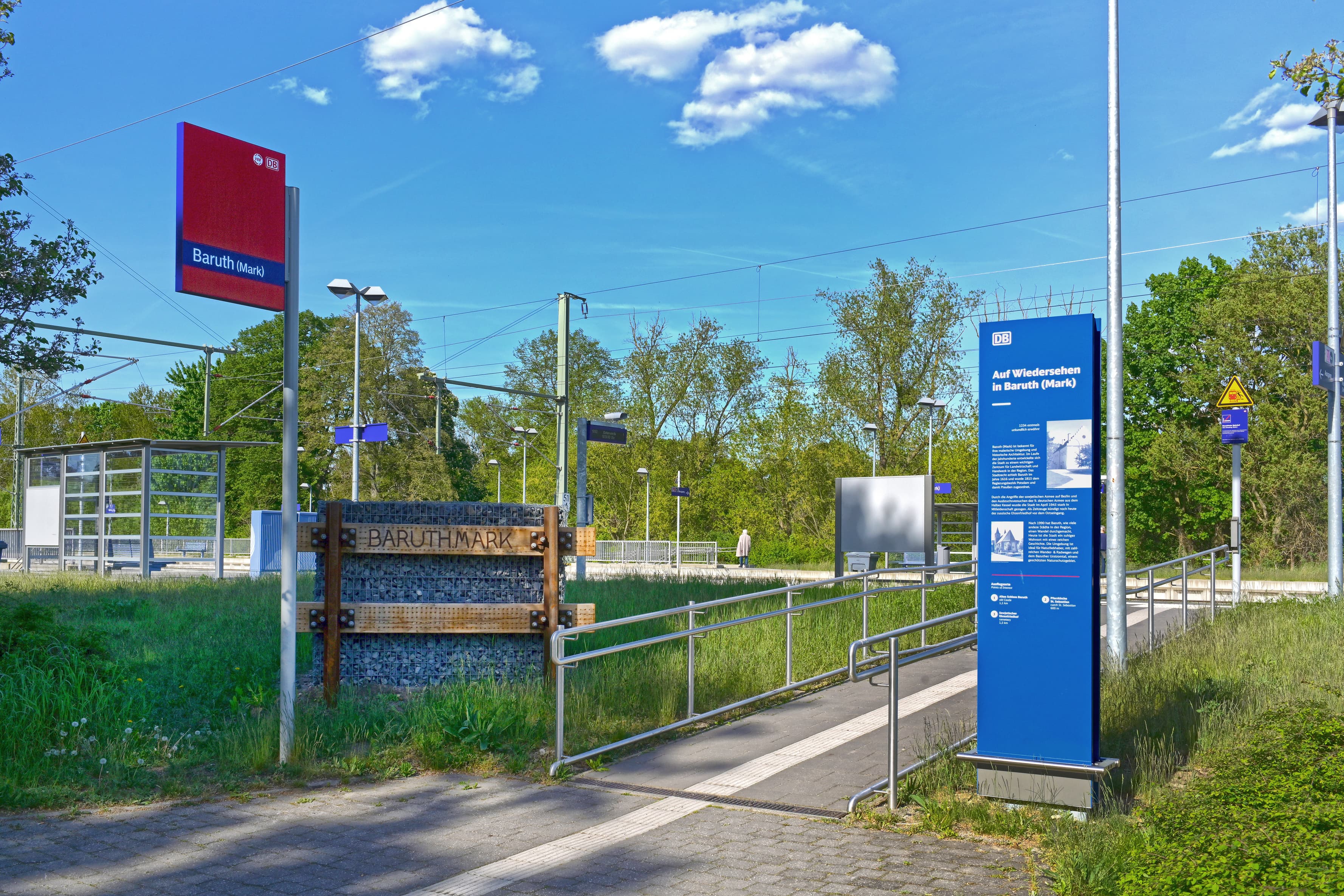 Beschilderung und Informationssäule am Zugang zum Bahnhof