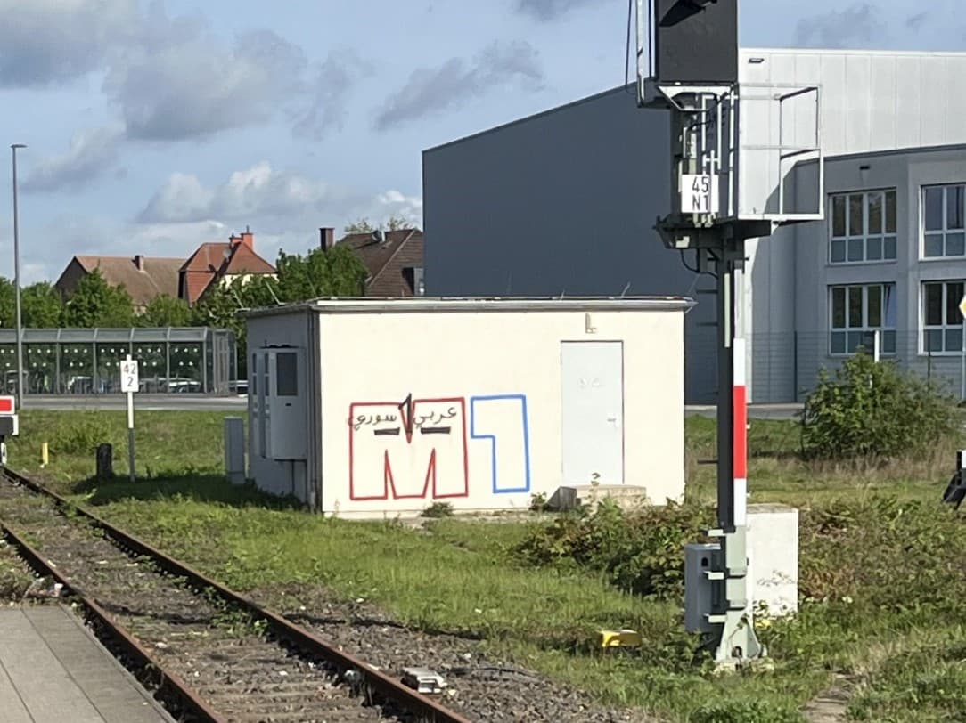 Das weiße Schalthaus vor der Umgestaltung mit Graffitibeschmierung.
