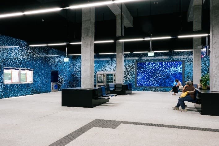 Wartebereich im neuen S15-Bereich mit Videoinstallation und Sitzgelegenheiten.