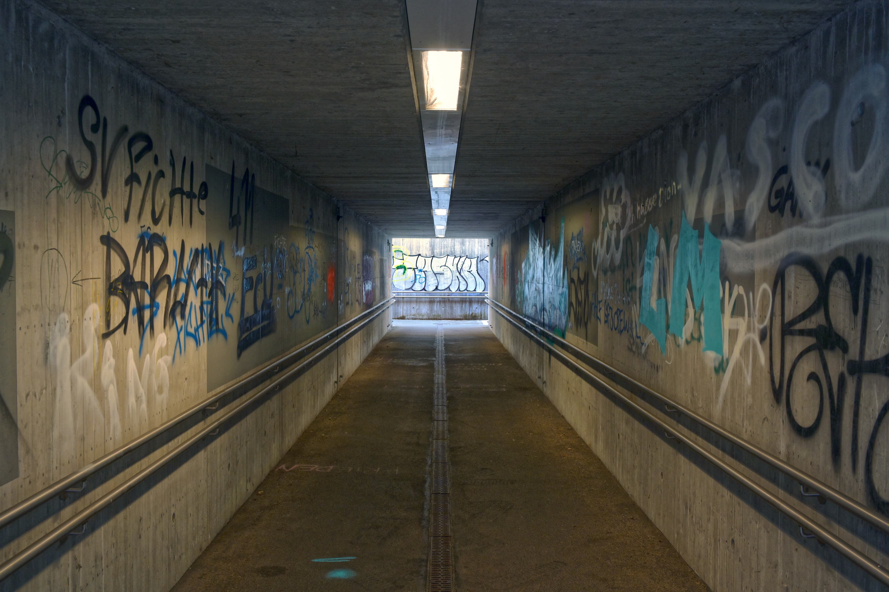 Eine Personenunterführung mit Graffiti beschmutzten Wänden.