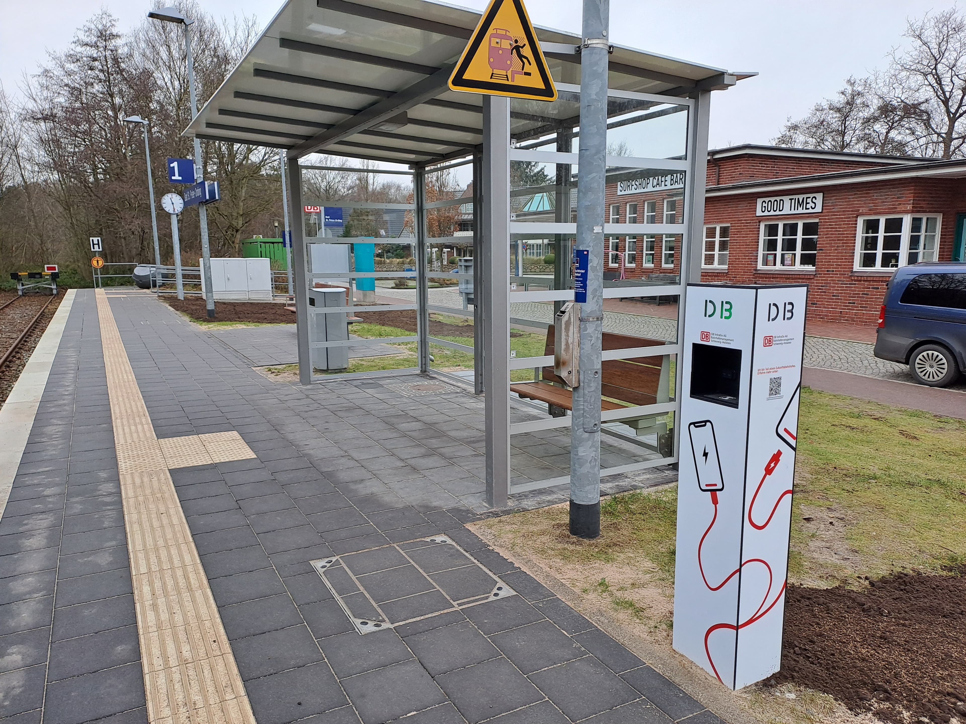 Im Vordergrund die Ladesäule für Mobiltelefone, dahinter der moderne Wetterschutz.