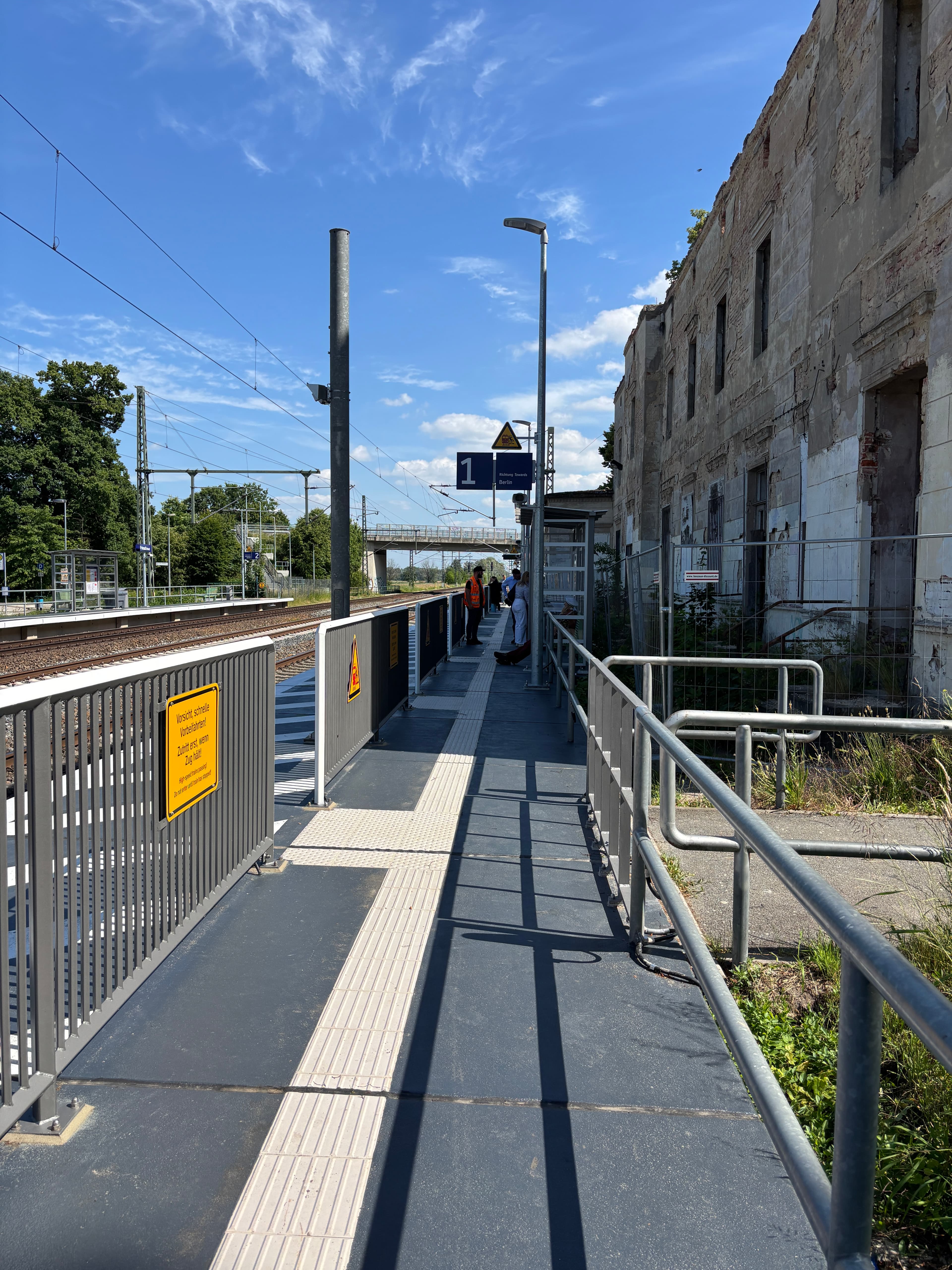 Ein modernisierter Bahnsteig, links Sicherheitsgeländer.